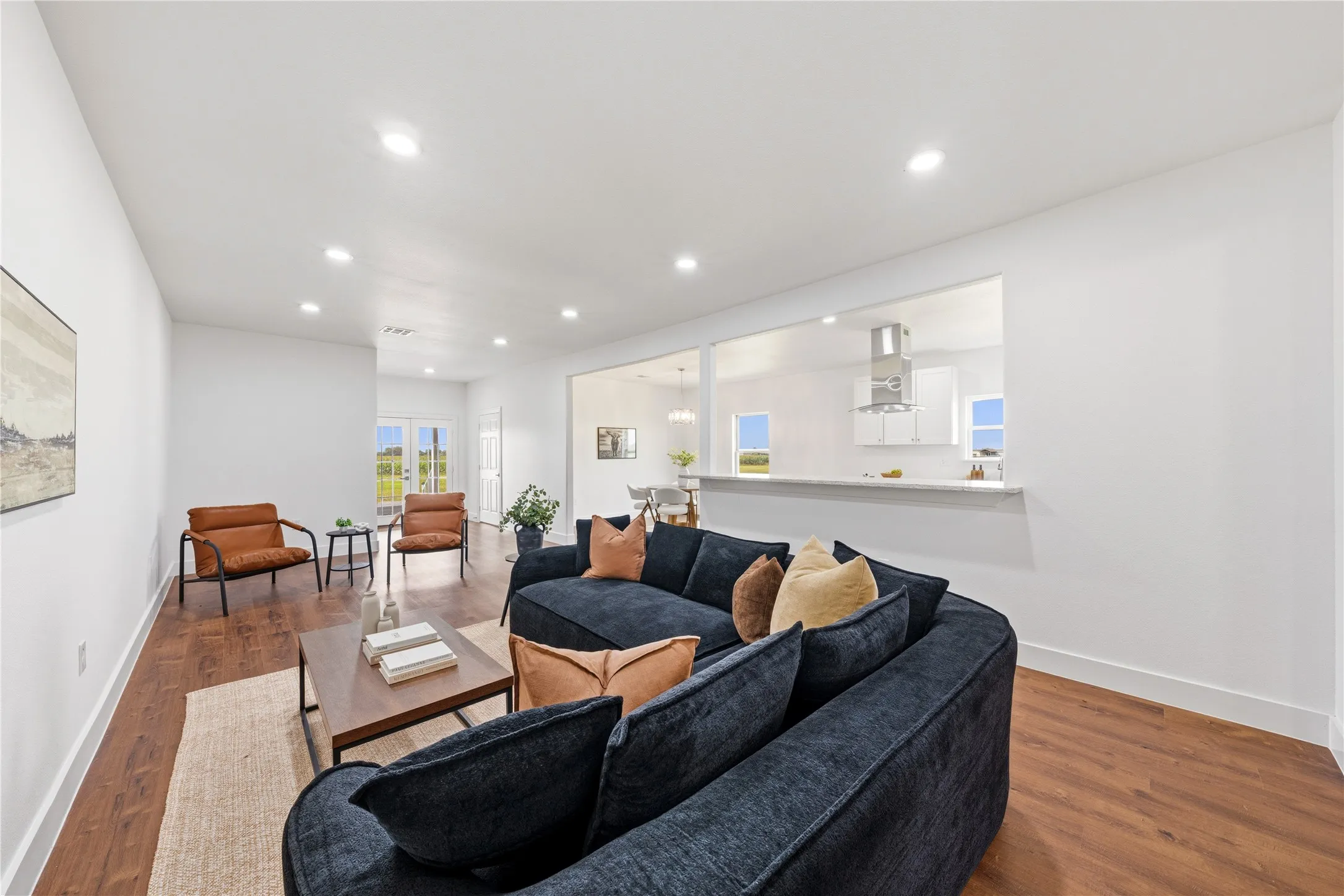 Open-concept living space featuring wood-finish flooring, recessed lighting, and white walls