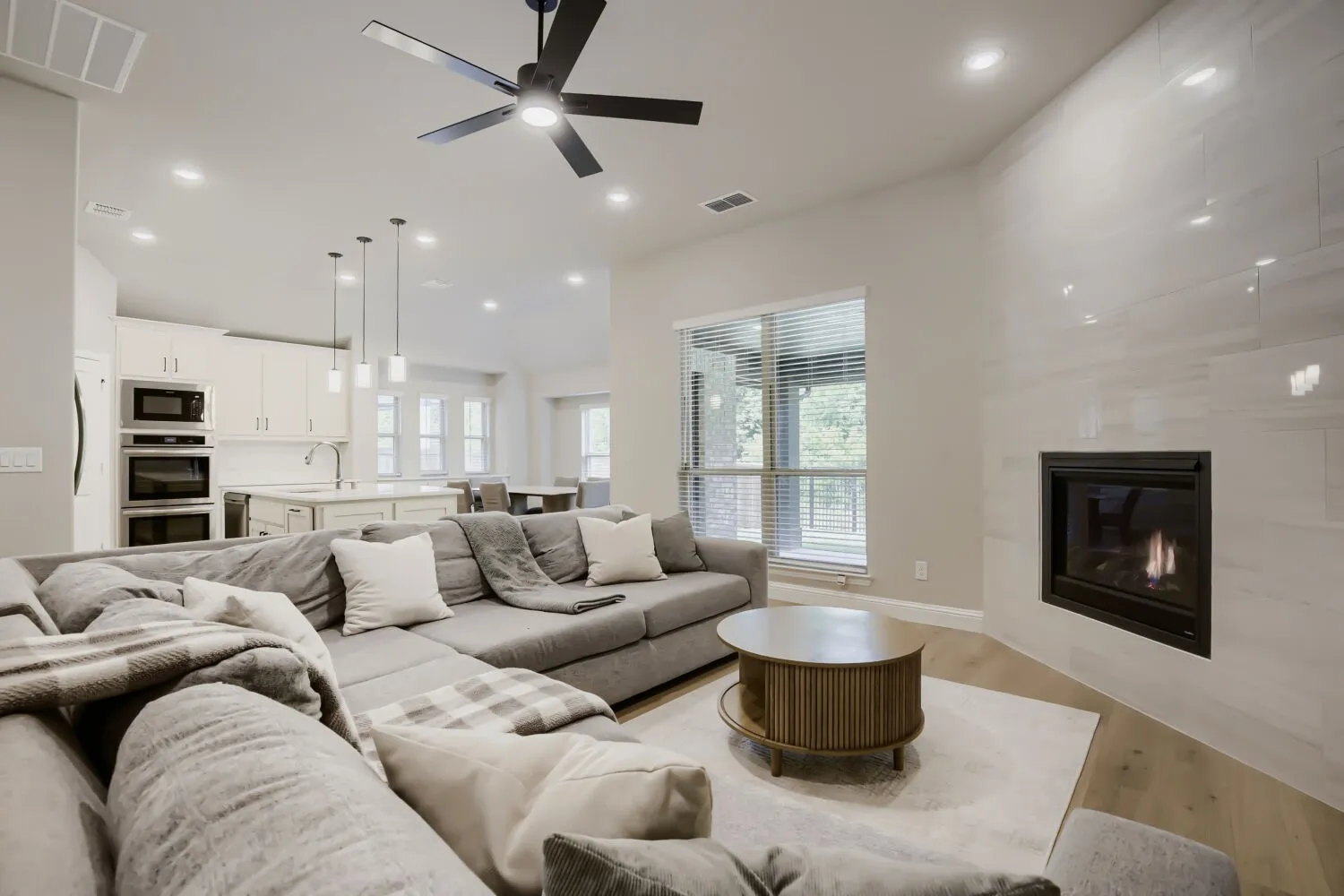 Living area featuring a floor-to-ceiling tiled fireplace, recessed lighting, and a modern ceiling fan
