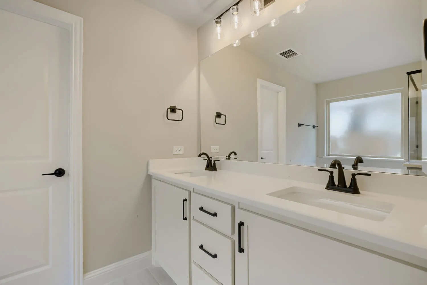 Dual vanity with integrated sinks, white countertops, and matte black fixtures