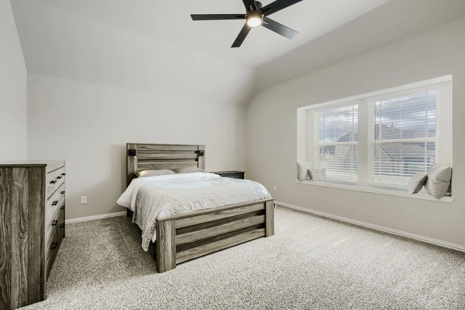 Bedroom featuring a vaulted ceiling and a built-in window seat