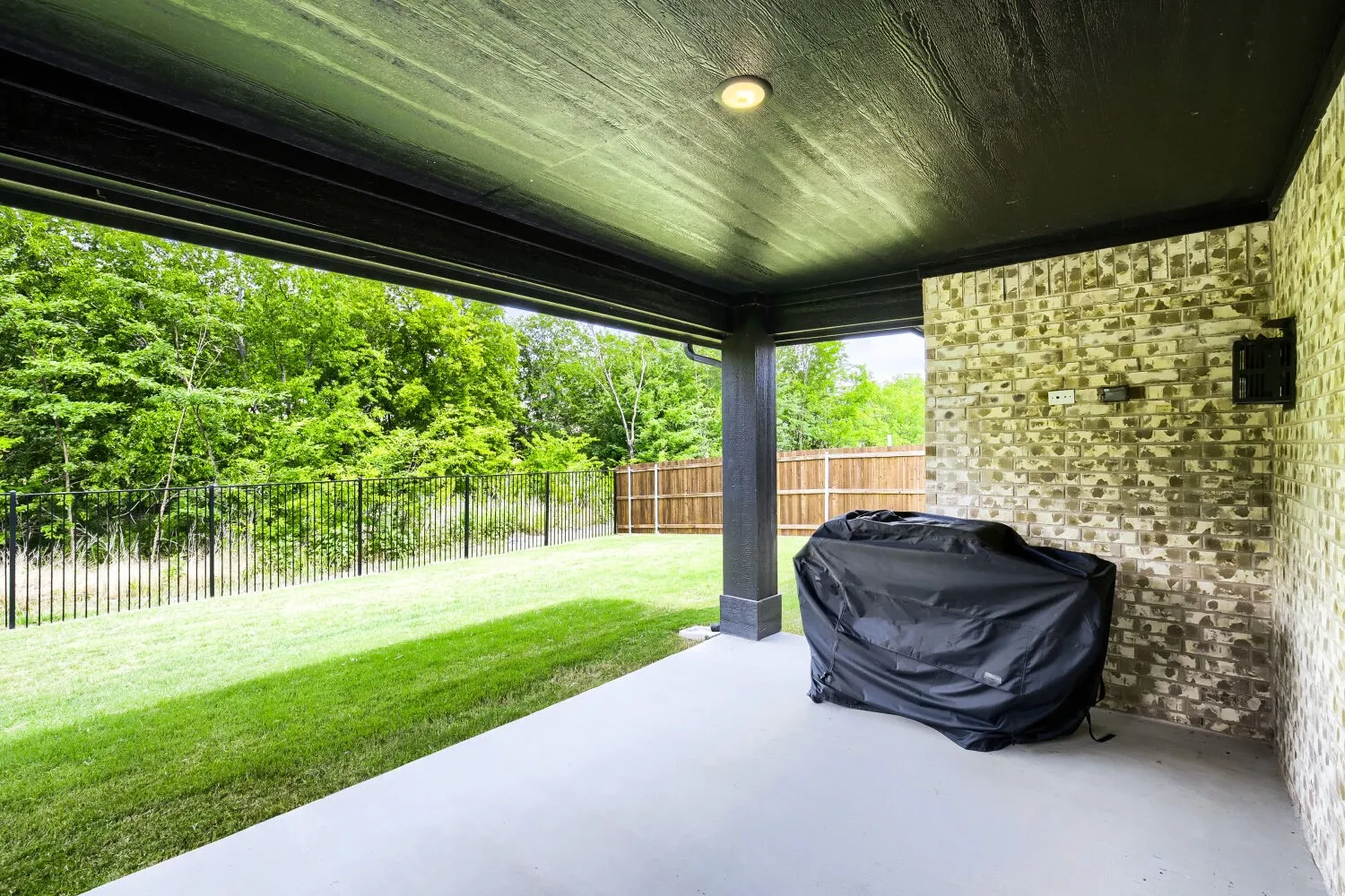 Covered patio with a smooth concrete slab and a painted wood-finish ceiling