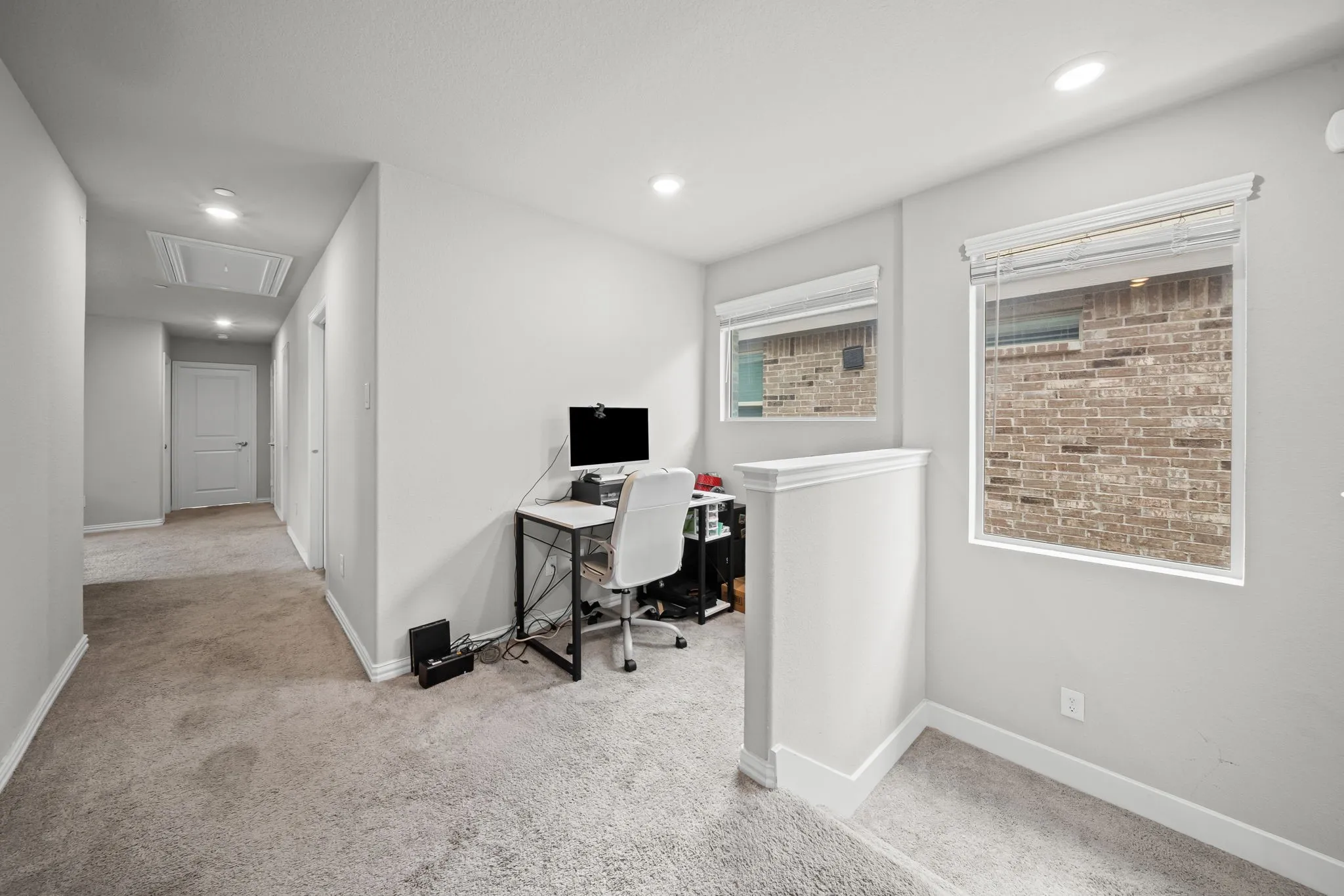 Carpeted hallway featuring recessed lighting and white trim