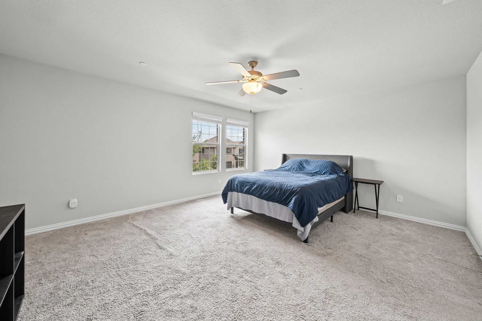 Carpeted bedroom featuring neutral walls and a ceiling fan with integrated​​‌​​​​‌​​‌‌​‌‌​​​‌‌​‌​‌​‌​​​‌​​ lighting