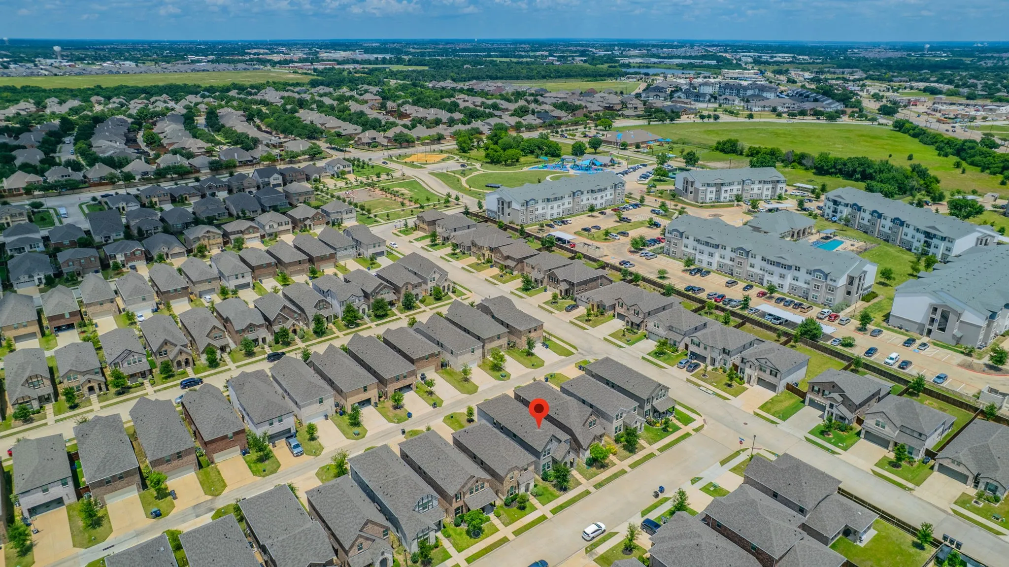 Aerial perspective showcasing a residential neighborhood with uniform rooflines and manicured lawns