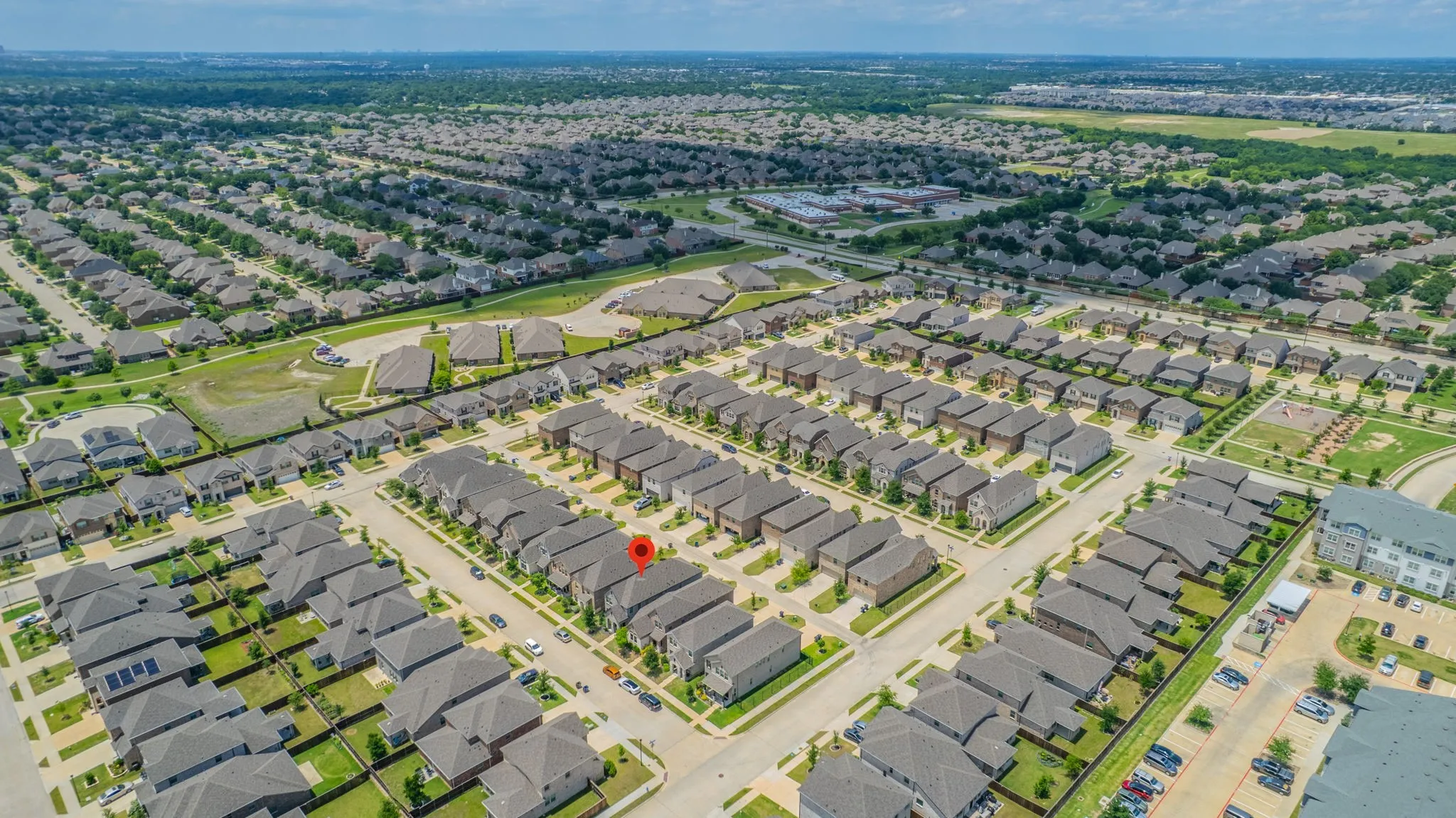 Aerial perspective showcasing a residential neighborhood with uniformly designed homes and verdant green spaces