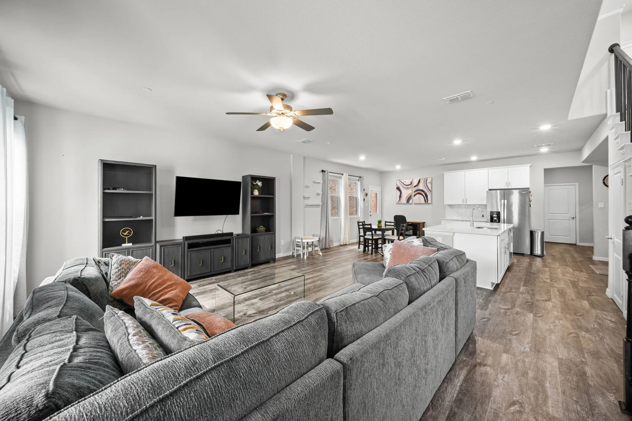 Open-concept living space featuring wood-finish flooring, recessed lighting, and a ceiling fan