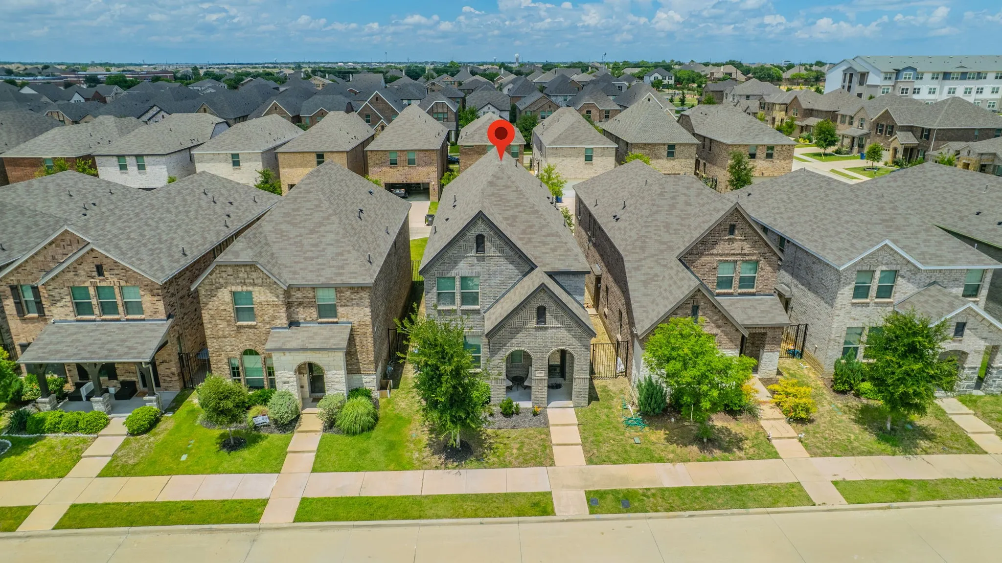 Two-story residence featuring a gray brick and stone exterior with a prominent front-facing gable