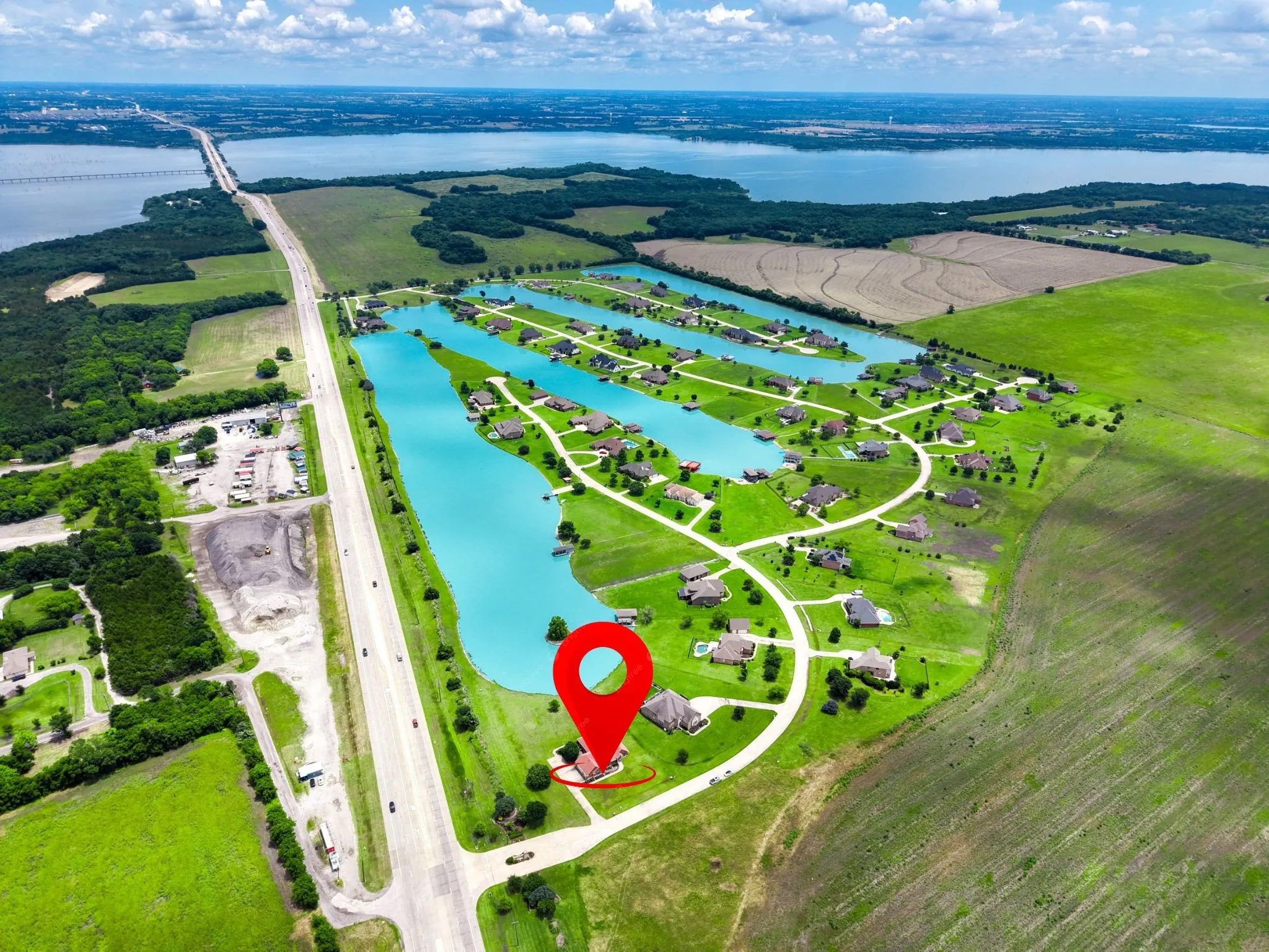 Aerial perspective highlighting a residential development with individual properties situated along a series of interconnected water features