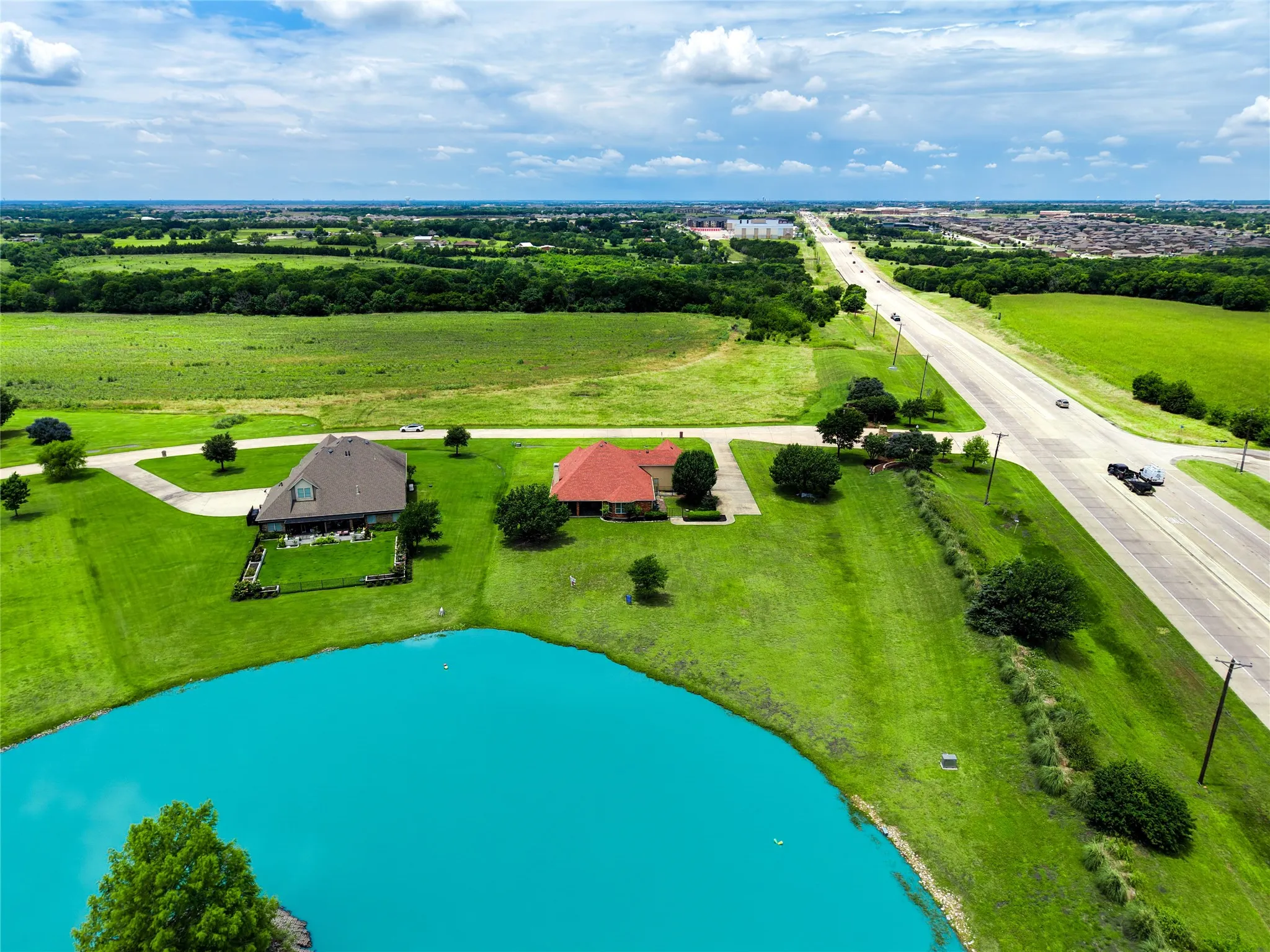 Expansive property featuring a tranquil pond and direct road access