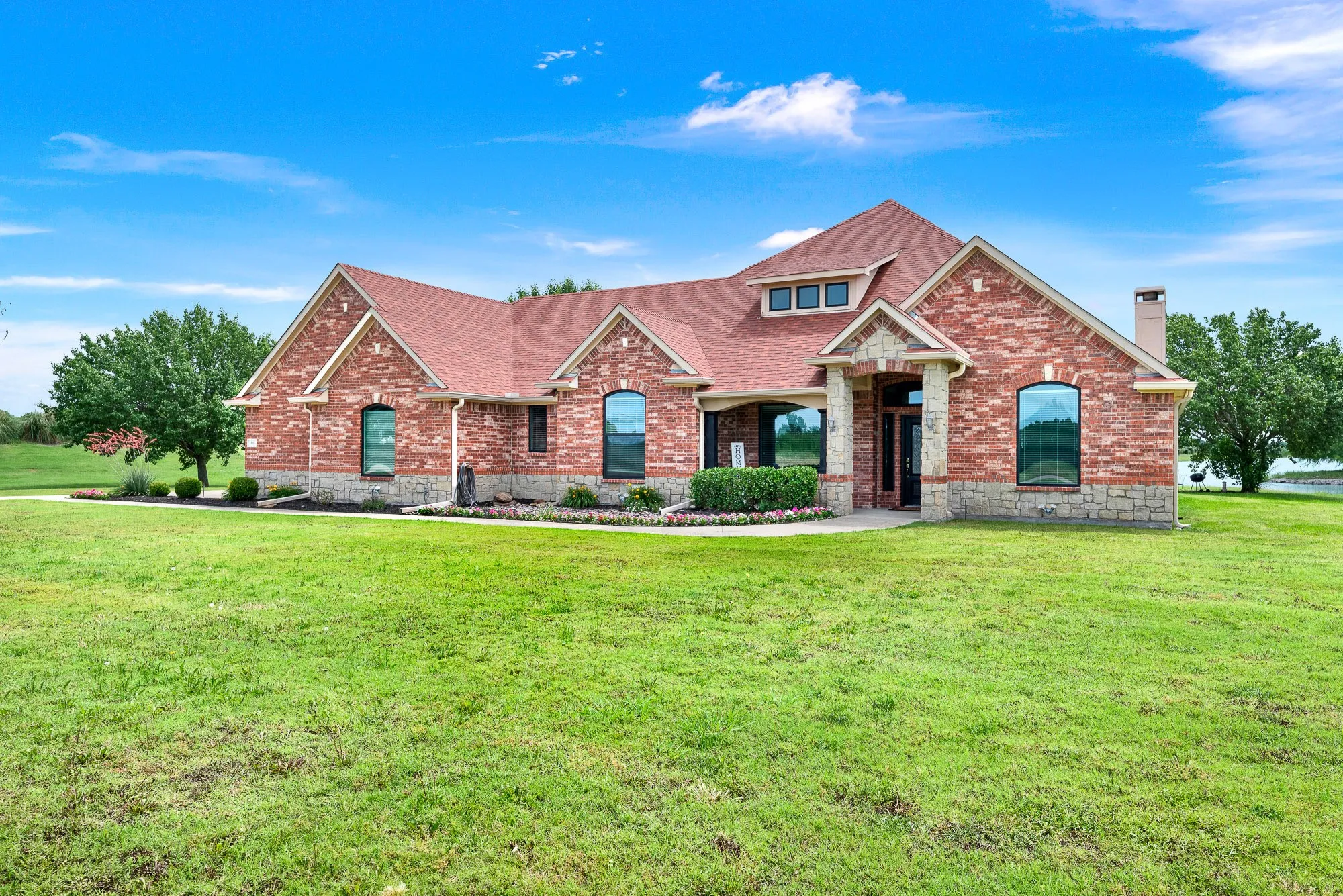 Brick and stone exterior featuring multiple gables and dormer windows