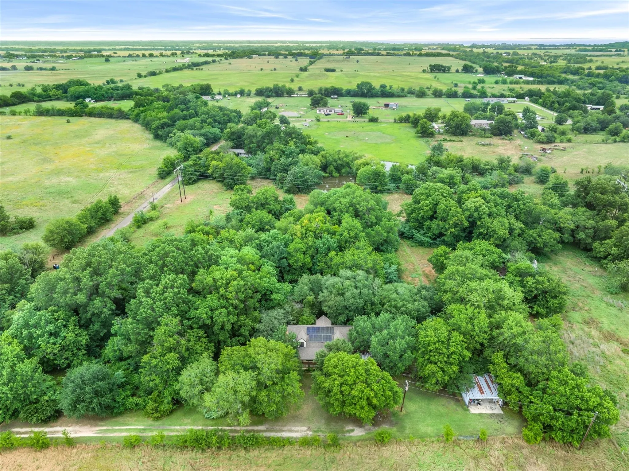 Farmhouse on 8.9 acres, secluded by greenery and oak trees.