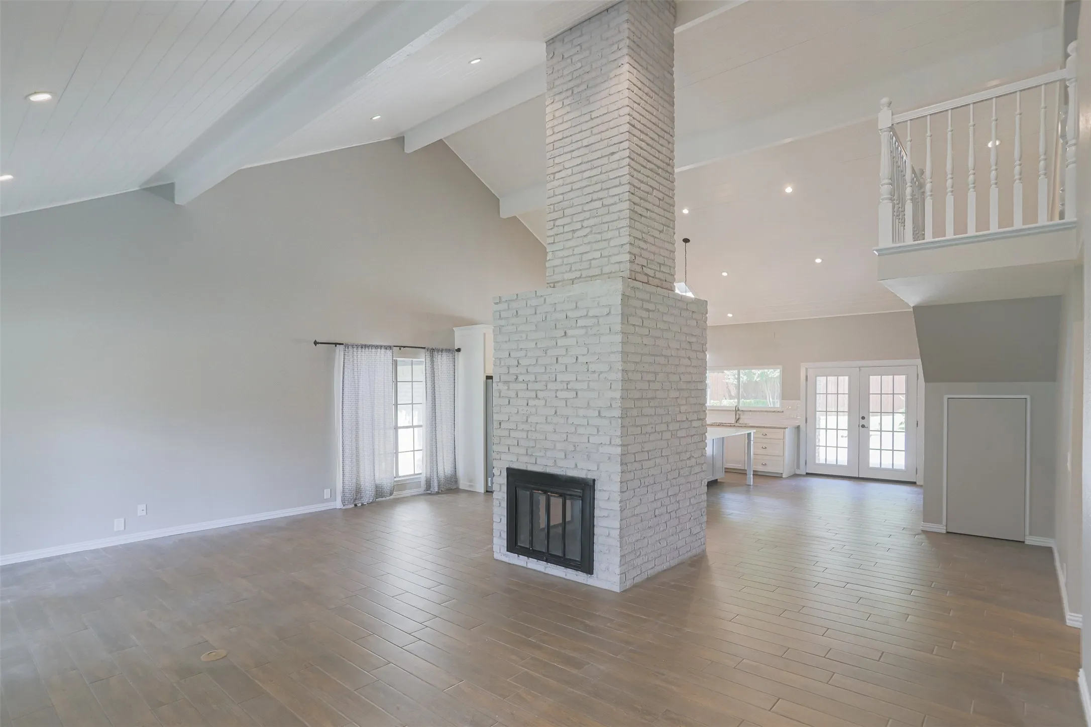 Expansive family room featuring fireplace and dramatic ceiling height.