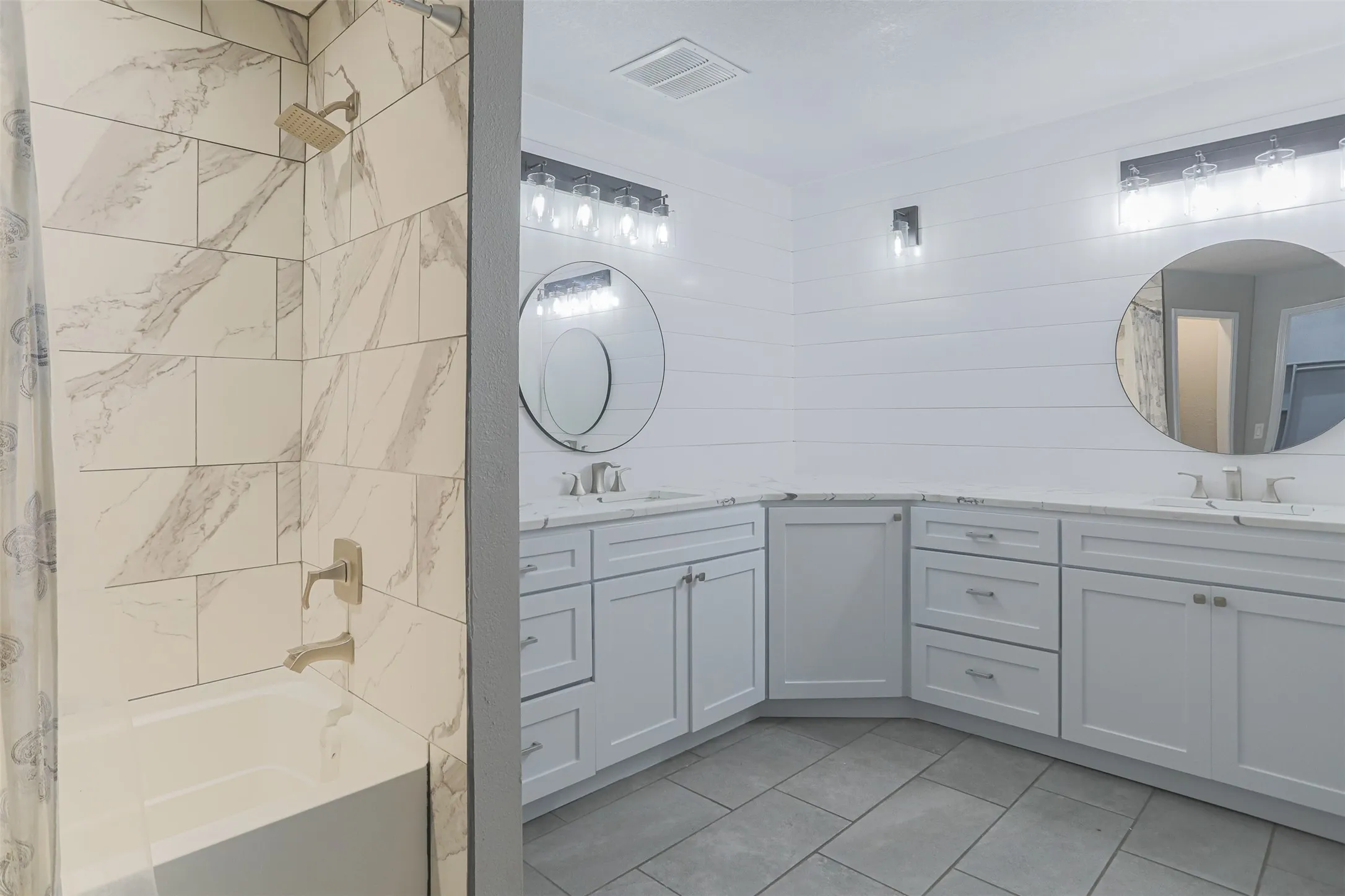 Updated primary bath with shower/tub and dual vanities, and walk-in closet.