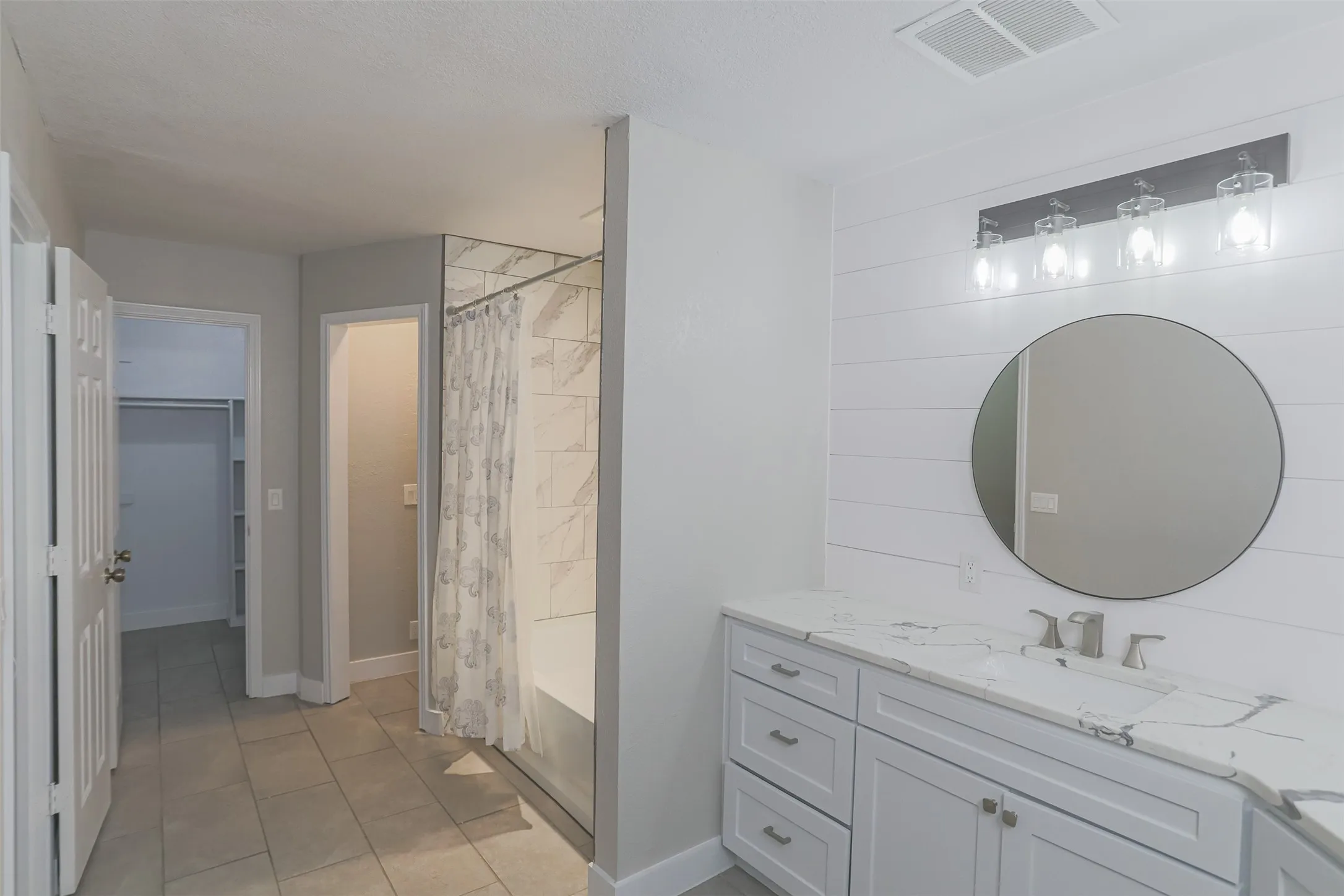 Updated primary bath with shower/tub and dual vanities, and walk-in closet.