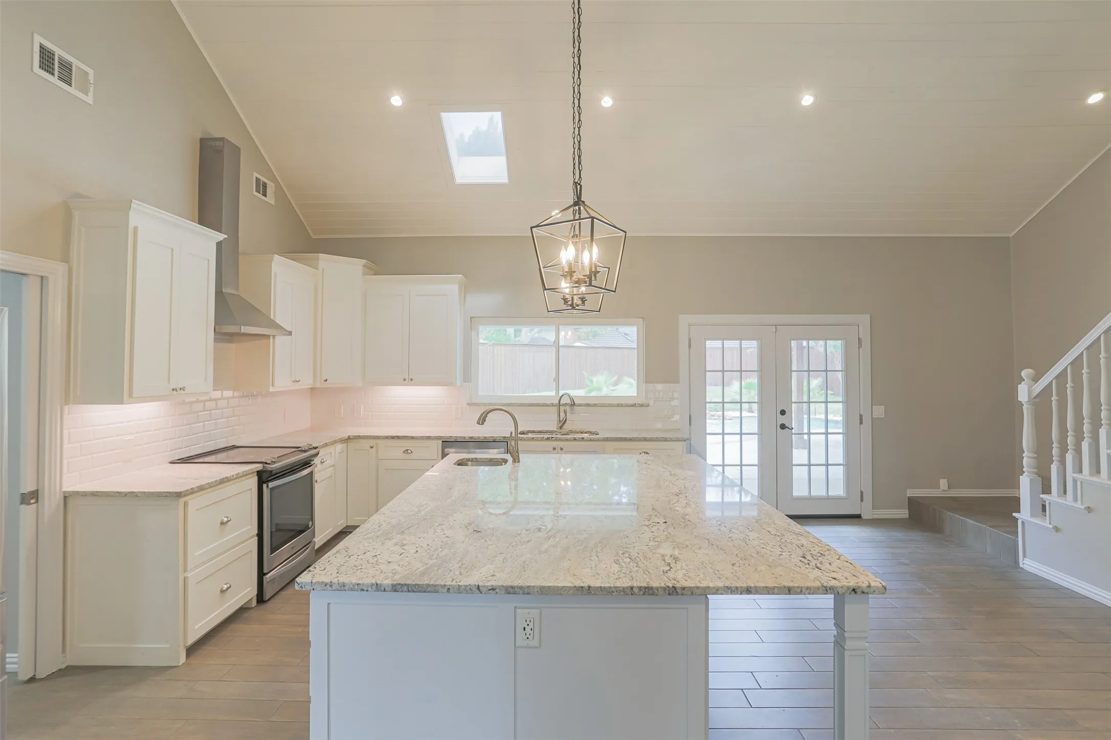 Beautifully updated kitchen featuring large center island and custom cabinetry