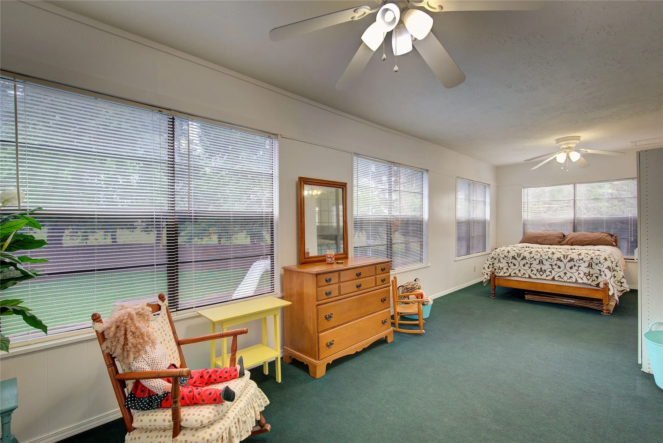 This huge sunroom off of the primary upstairs suite, has tons of windows, ceiling fan, separate Ac unit.  Could be a play room, solarium, or guest bedroom.