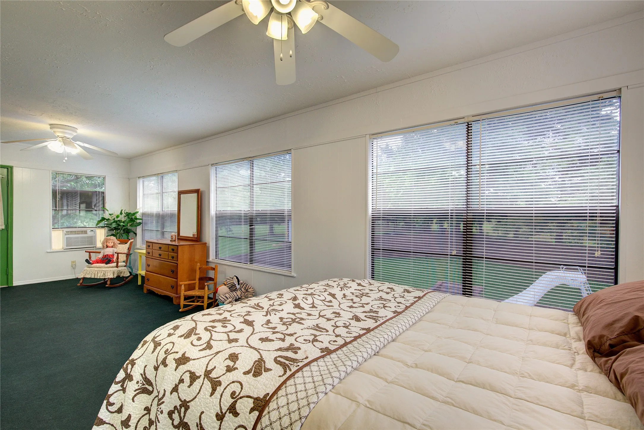 This sunroom off of the primary upstairs suite has wall of windows overlooking the pool and a separate AC unit. Opens onto a 2nd-floor balcony.