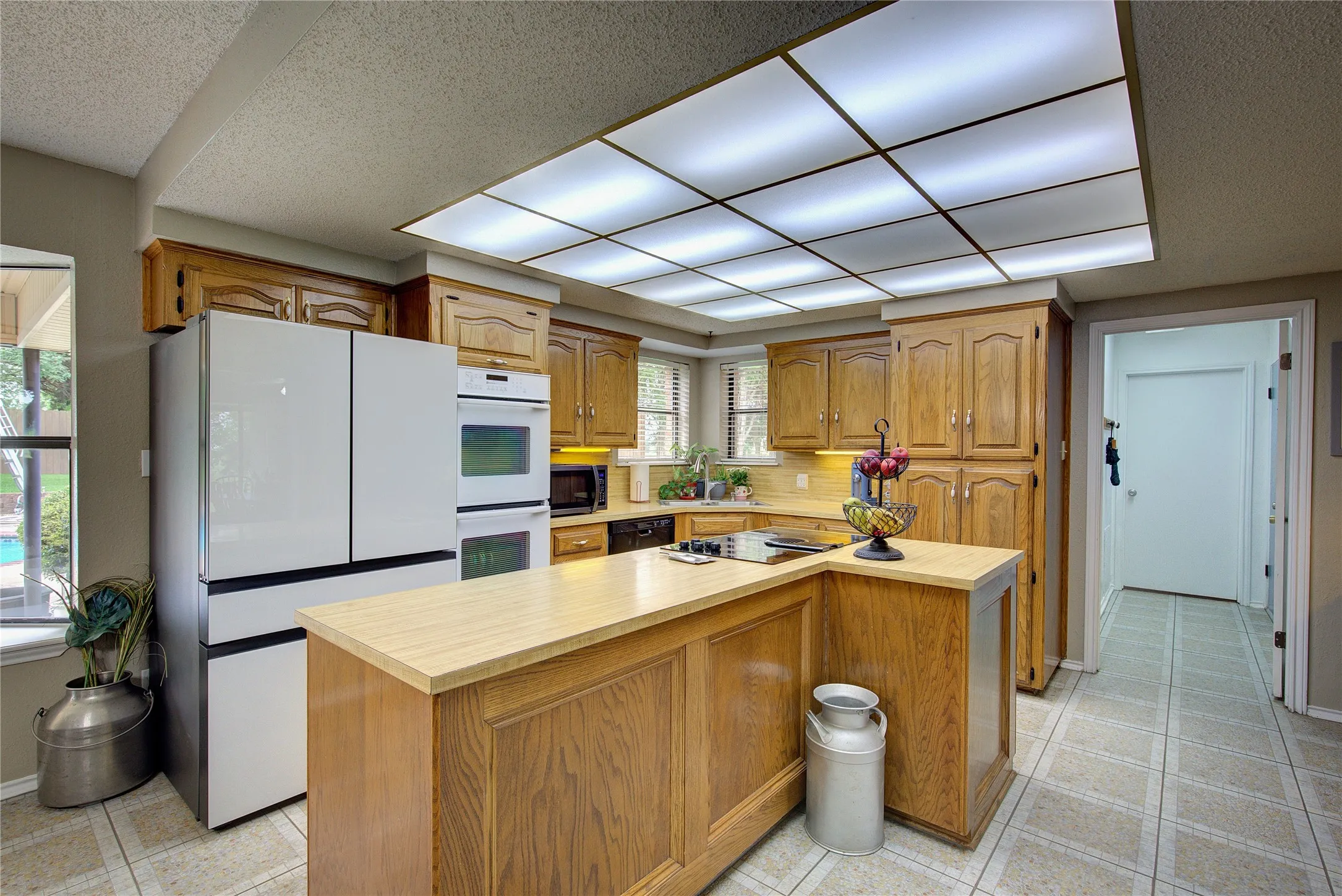 Kitchen has large island, double wall ovens, corner sink, electric cooktop, dishwasher and pantry cabinet. Walk-in pantry is just steps away.
