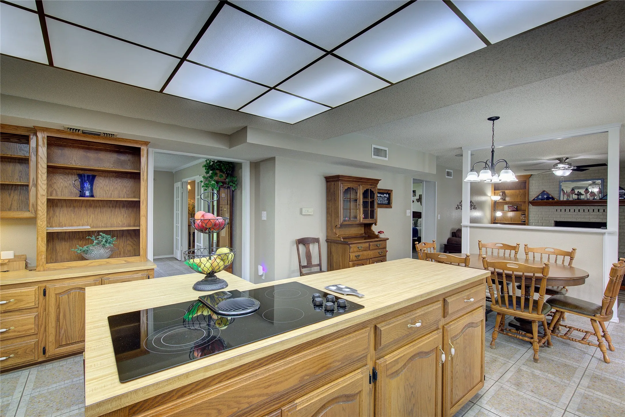 Kitchen has large island with cooktop, desk area with extra storage, breakfast area