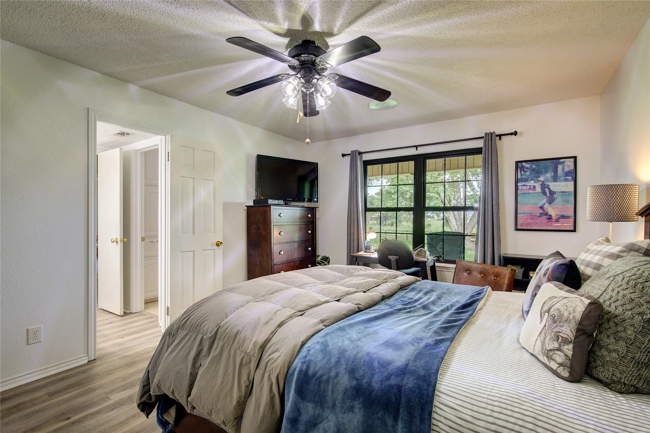 This house has TWO primary suites, one downstairs and on upstairs.  This downstairs primary suite has a double window, ceiling fan, and ensuite bath.