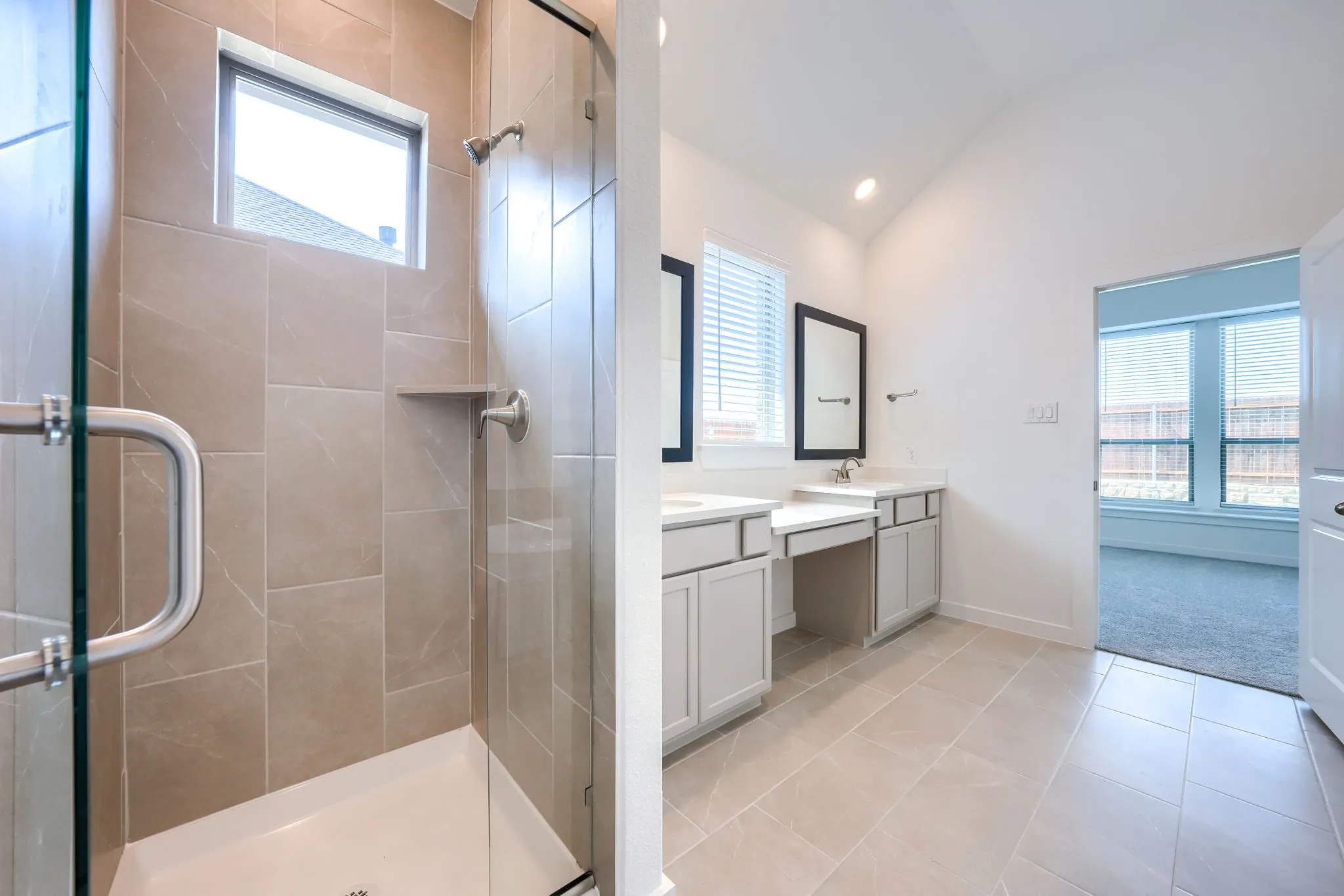 Glass-enclosed shower with tiled walls and a built-in shelf