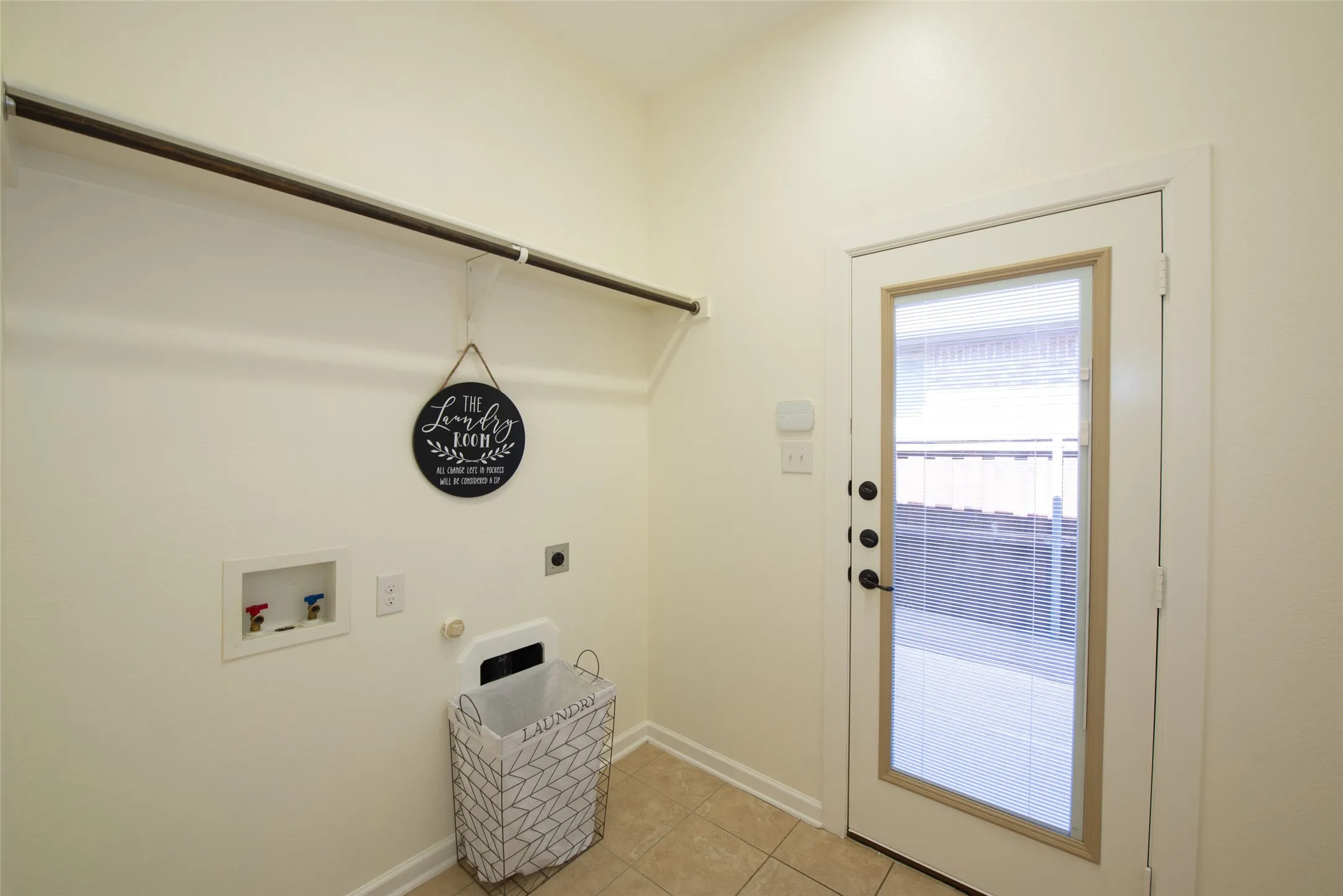 Utility space featuring an exterior door with a full-light window, tile flooring, and integrated wall shelving