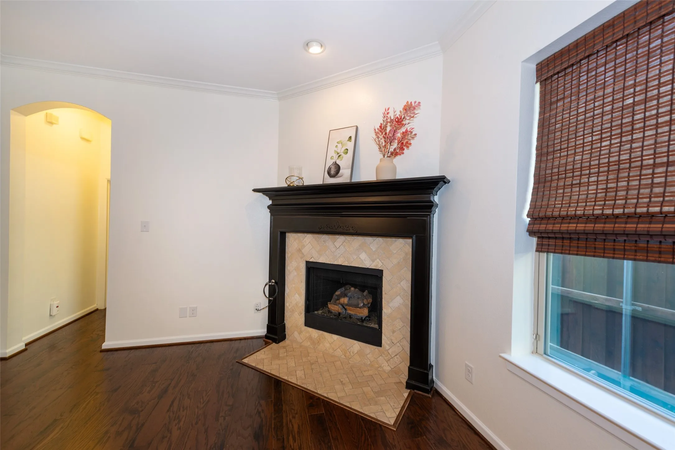 Fireplace with a black wood mantel and a herringbone tile surround