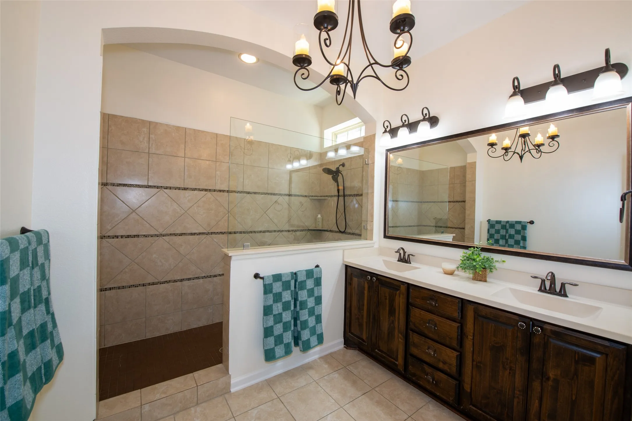 Expansive bathroom featuring a dual vanity with dark wood cabinetry and light countertops