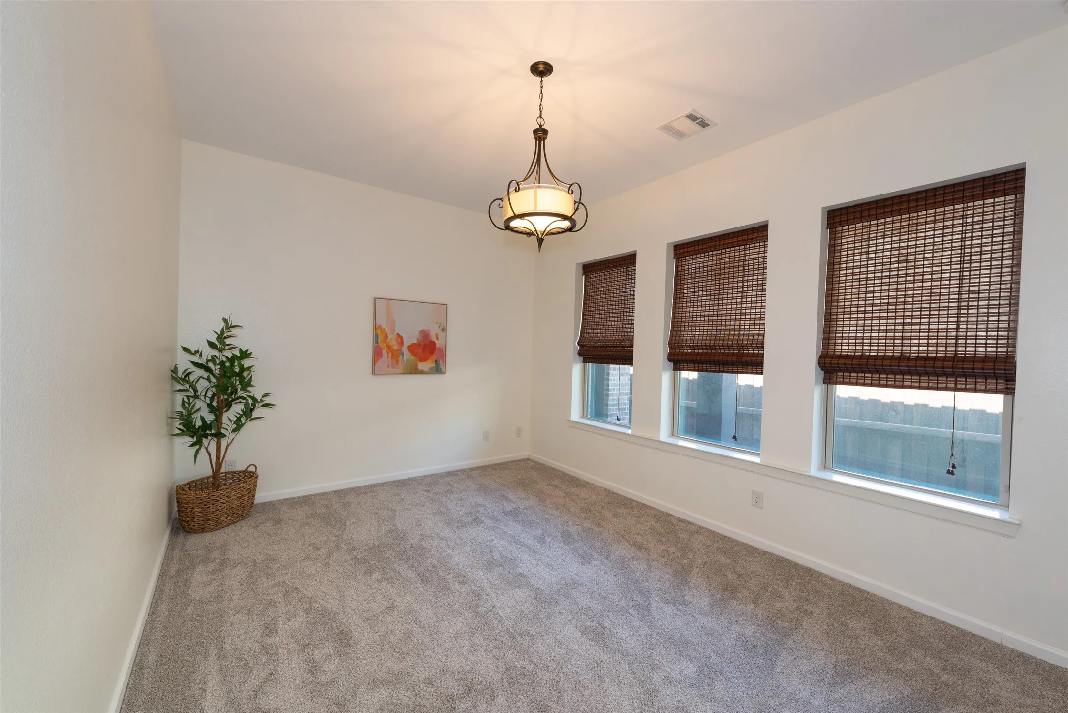 Room featuring neutral carpeting, white walls, and a multi-light chandelier