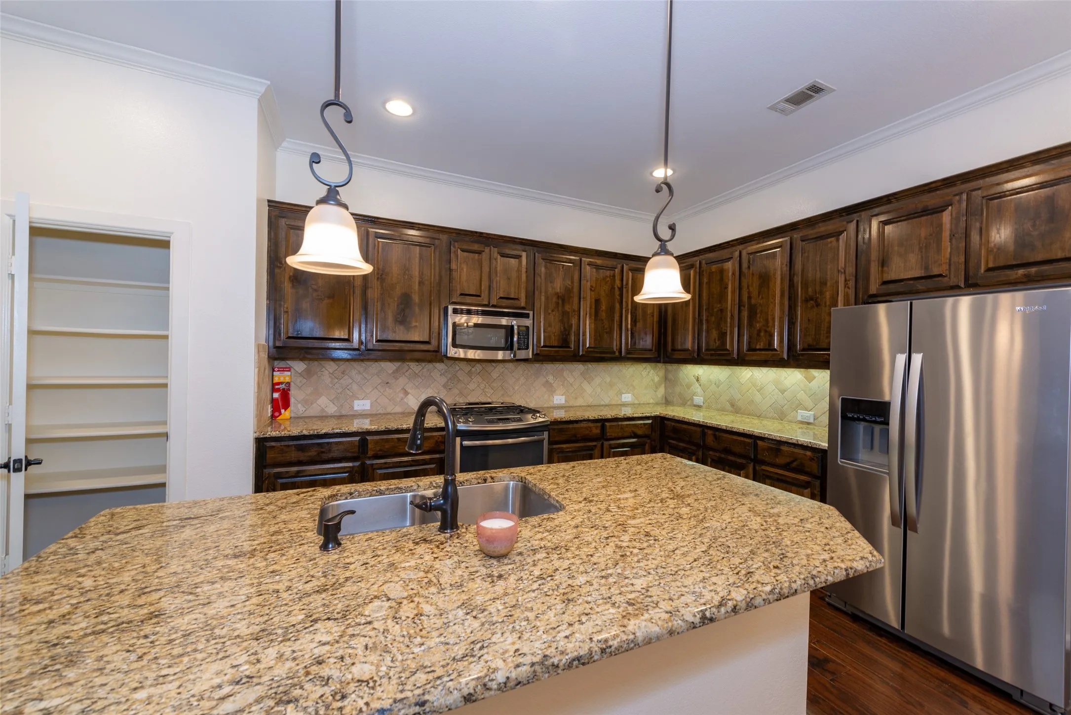 Kitchen featuring a large central island with a built-in sink and granite countertop