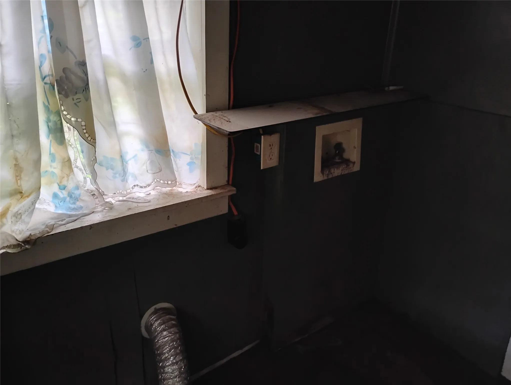 Window with natural light, utility hookups, and a wall-mounted shelf