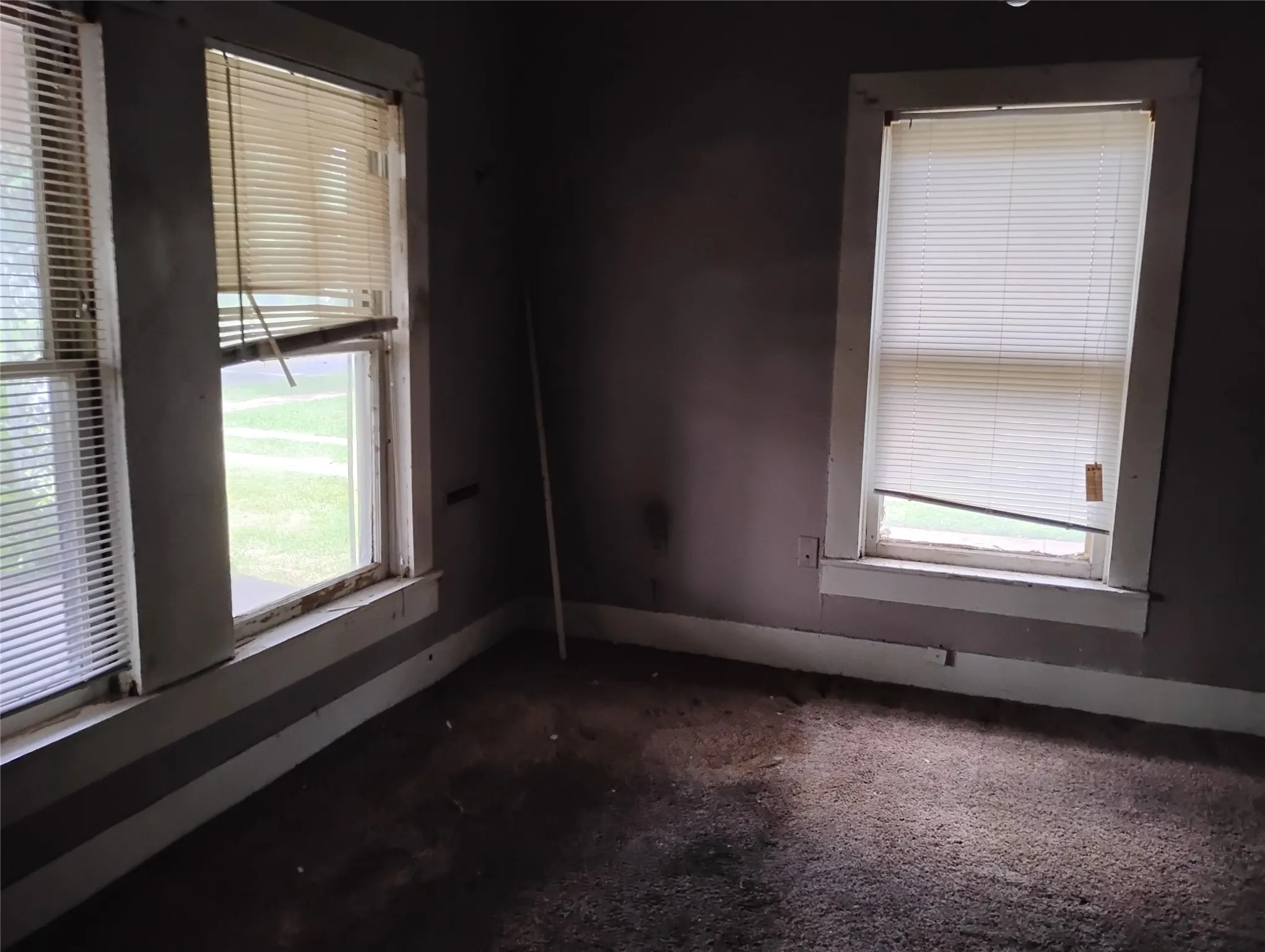 Room with two windows featuring white window trim and baseboards