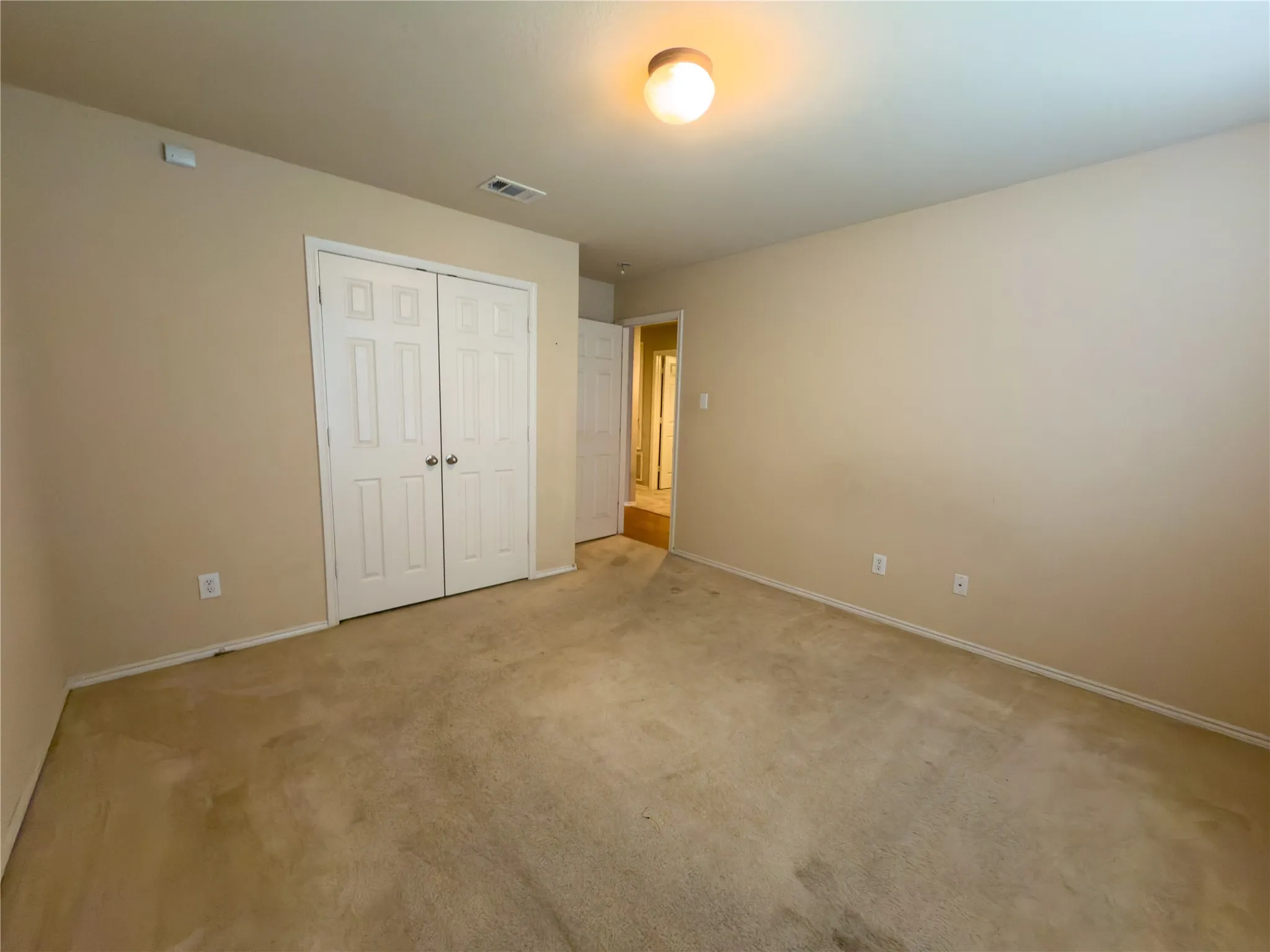 Neutral-toned walls complement the carpeted flooring