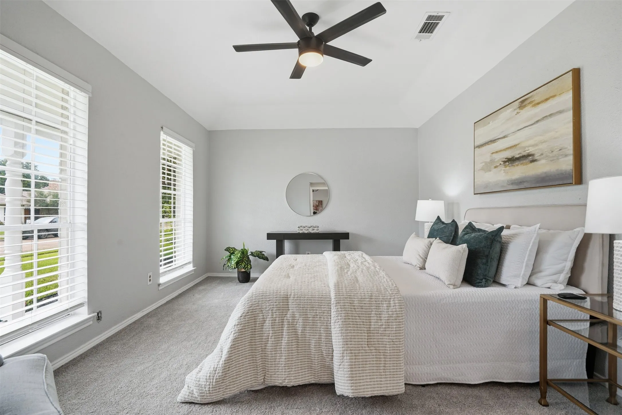 Carpeted room featuring two windows with white blinds, a tray ceiling, and a ceiling fan with integrated lighting