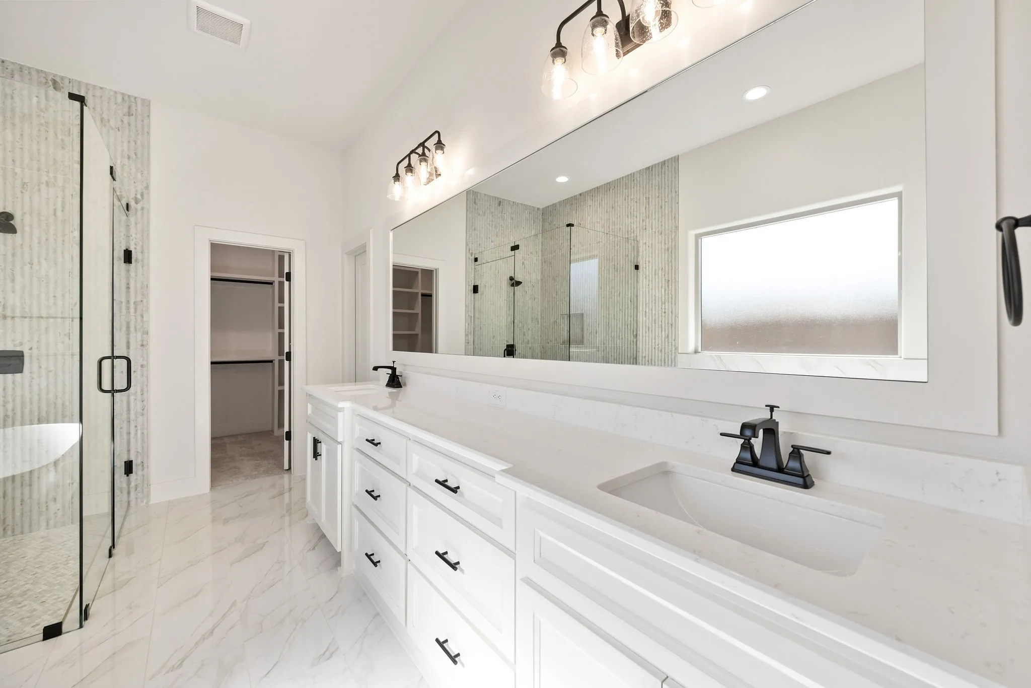 Dual vanity with white cabinetry, integrated sinks, and matte black fixtures