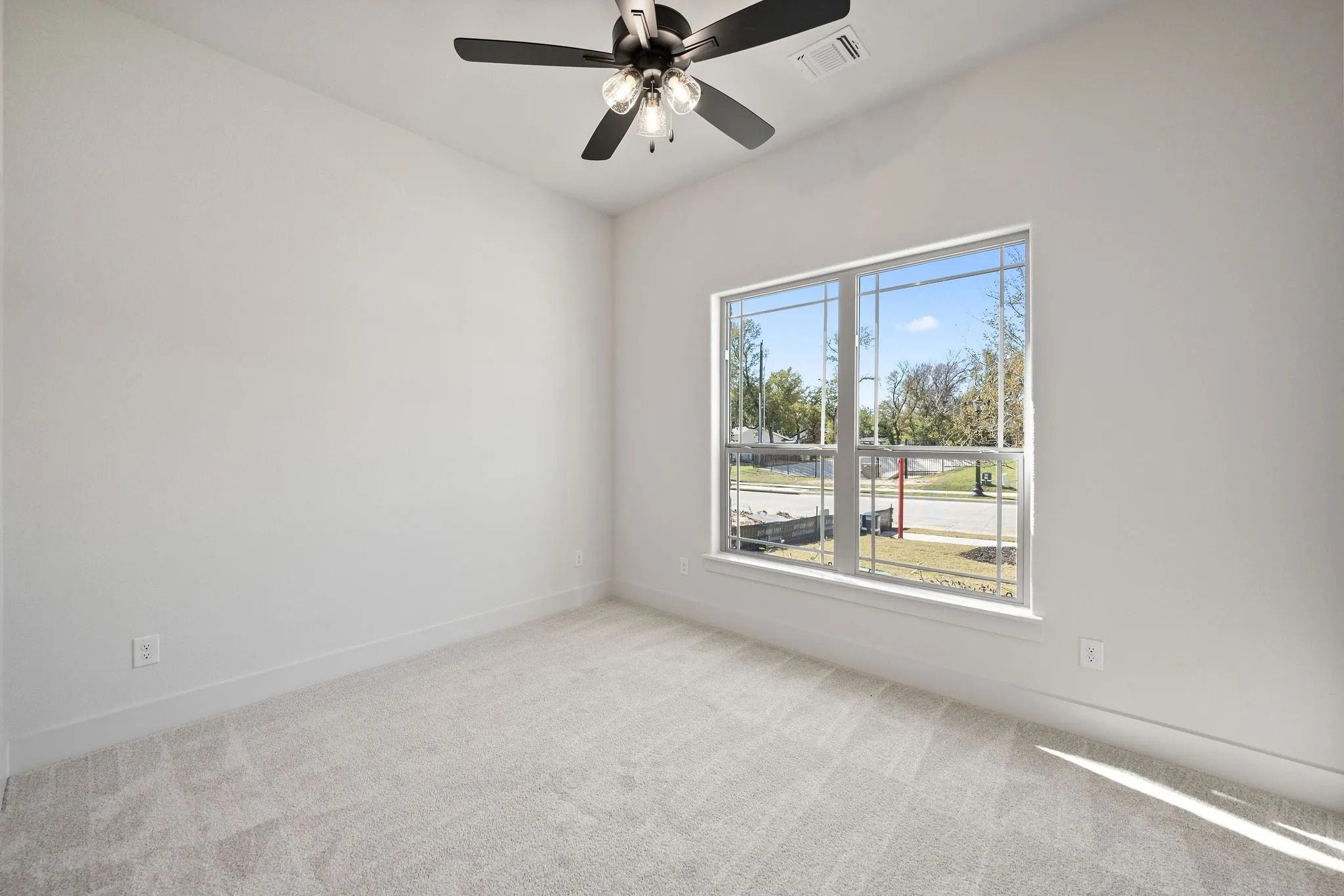Room featuring light gray carpet flooring, white walls, and a large window with white trim
