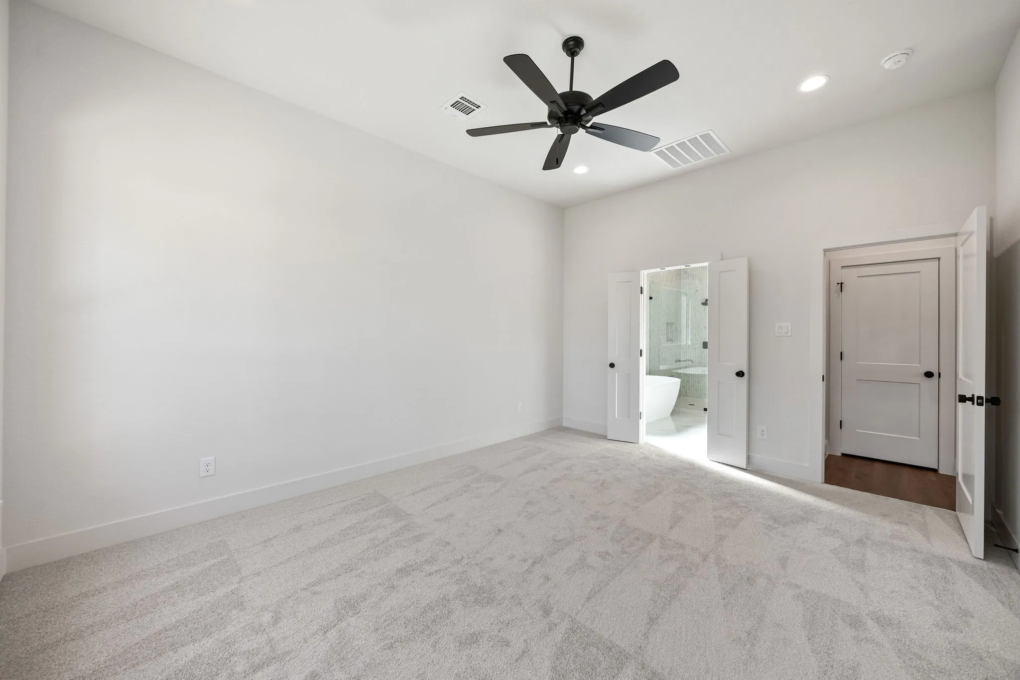 Spacious room with light-toned carpeting and neutral wall tones