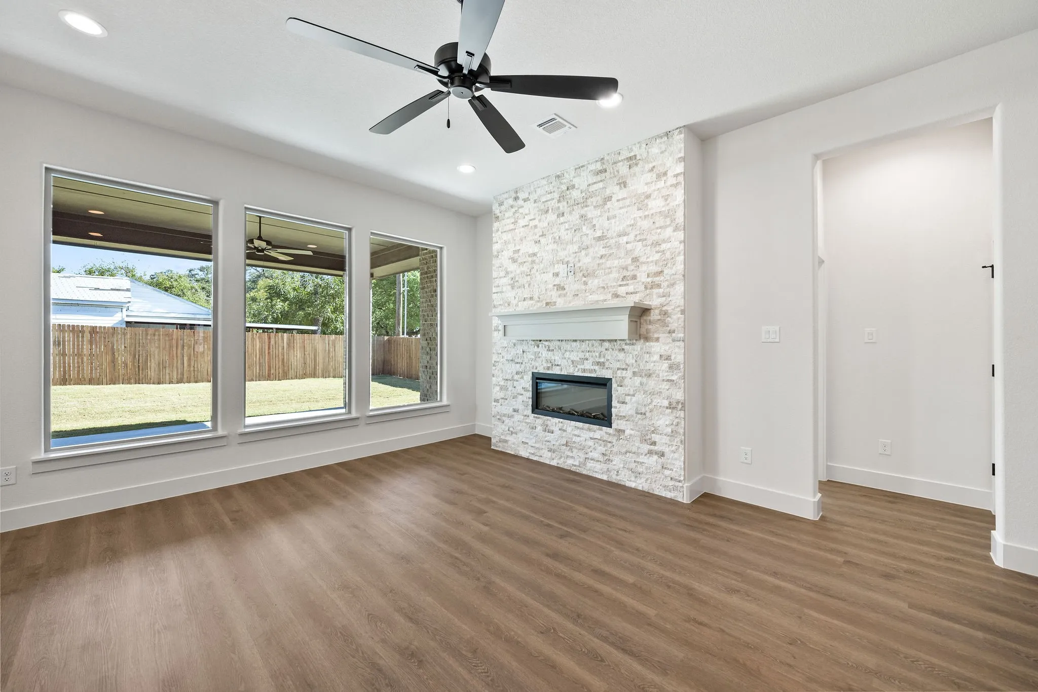 Living area featuring wood-finish flooring, a contemporary ceiling fan, and recessed lighting