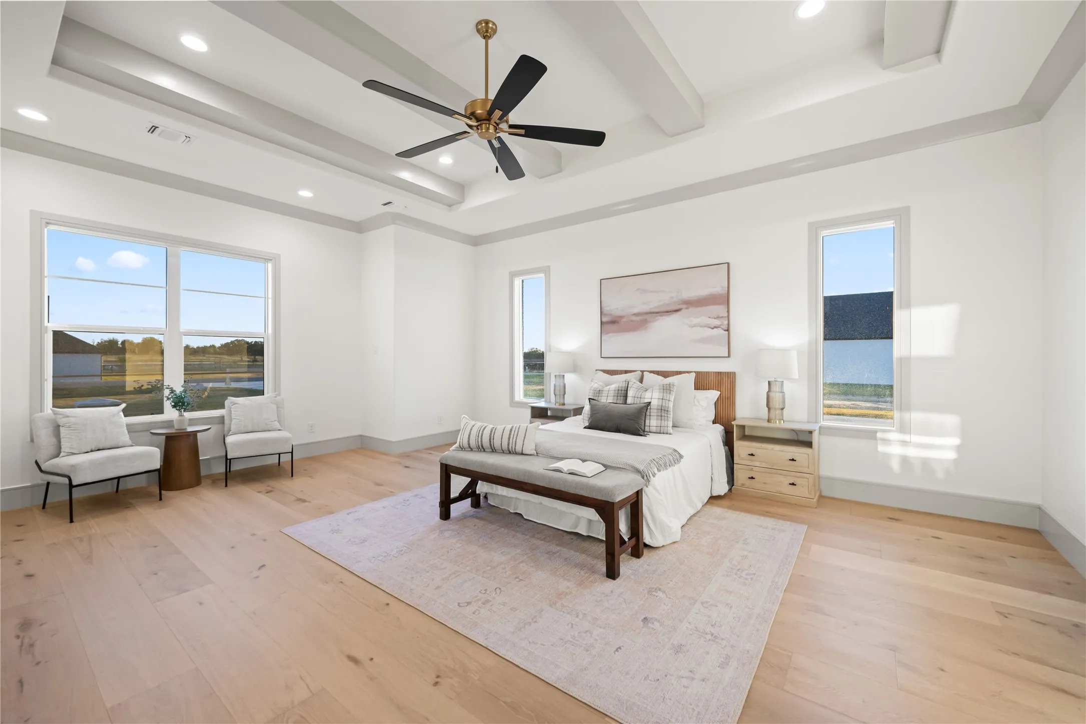 Spacious room featuring wood-finish flooring, a coffered ceiling with recessed lighting, and a modern ceiling fan