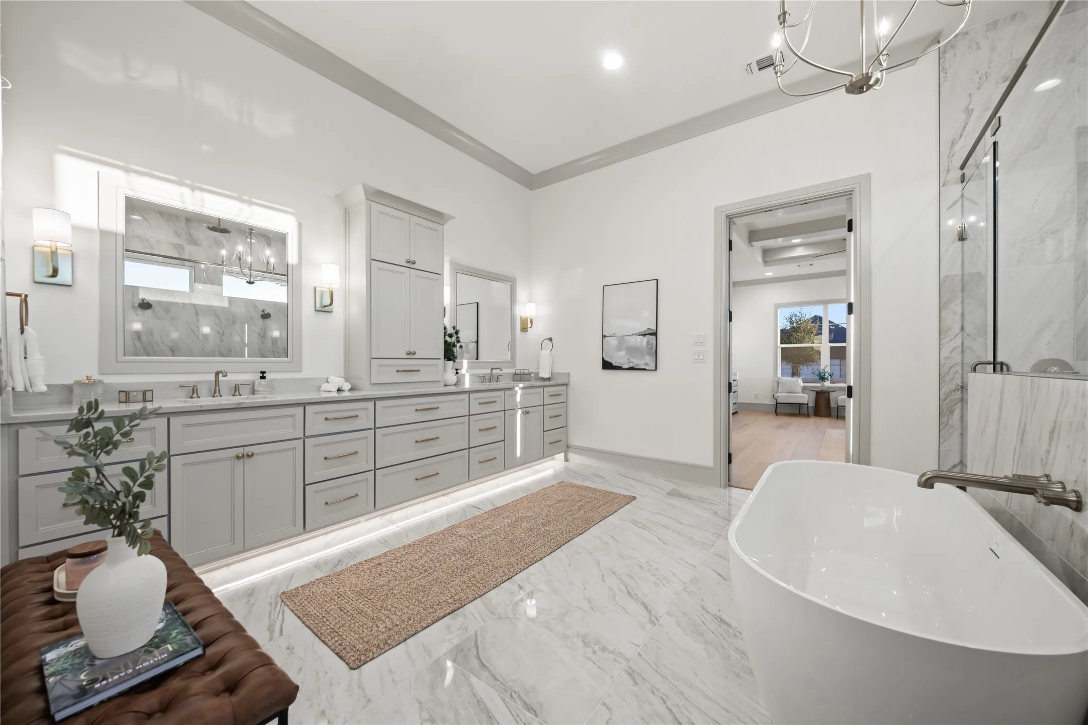 Spacious bathroom featuring a freestanding soaking tub, large vanity with dual sinks, built-in cabinetry, and tile flooring