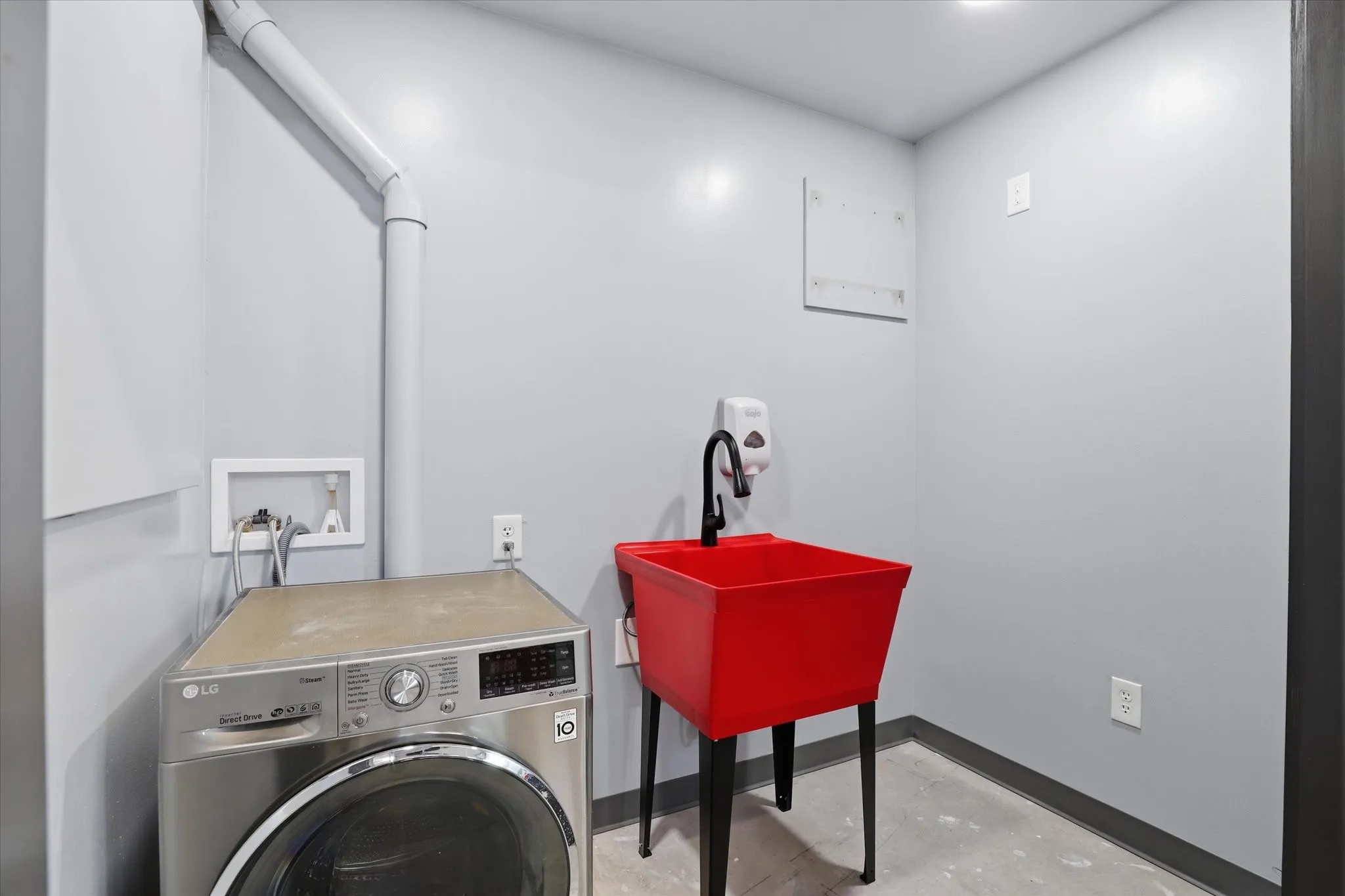Finished utility room with LG washer/dryer unit and utility sink
