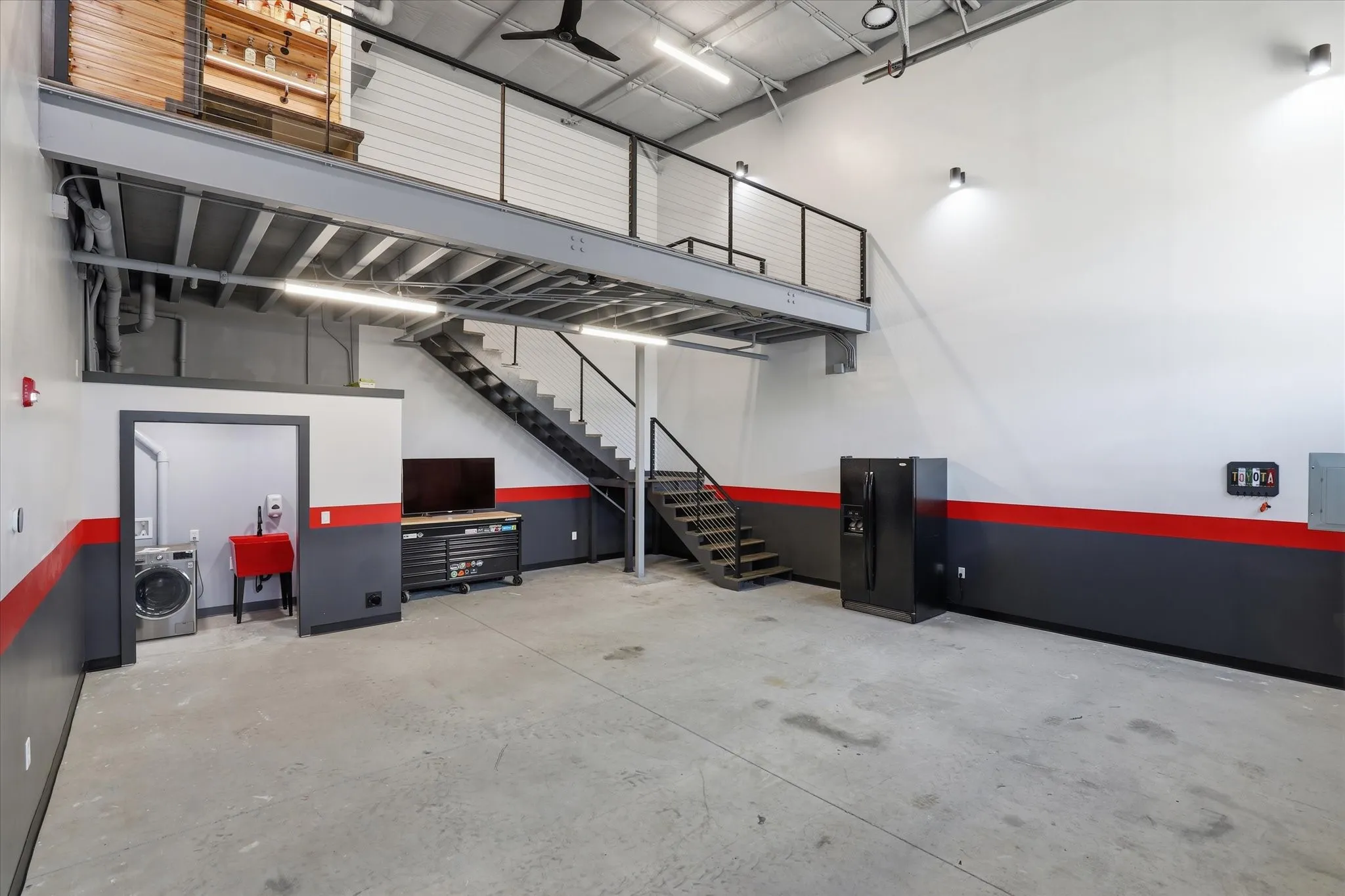 Open sightlines between floors. Bold red and black design accents throughout.