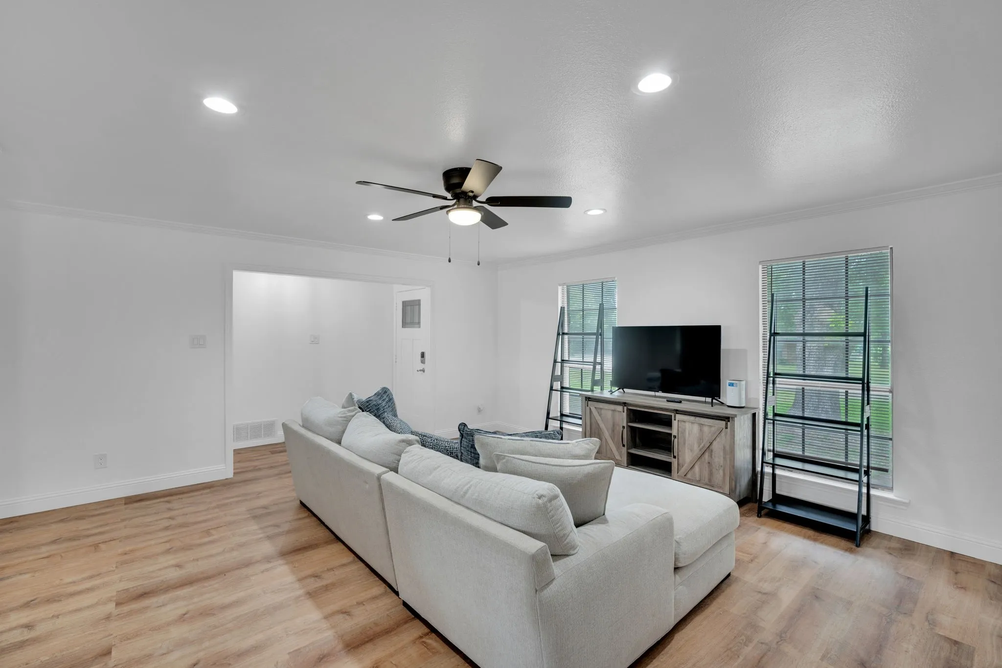 Spacious interior featuring wood-finish flooring, recessed lighting, and a ceiling fan