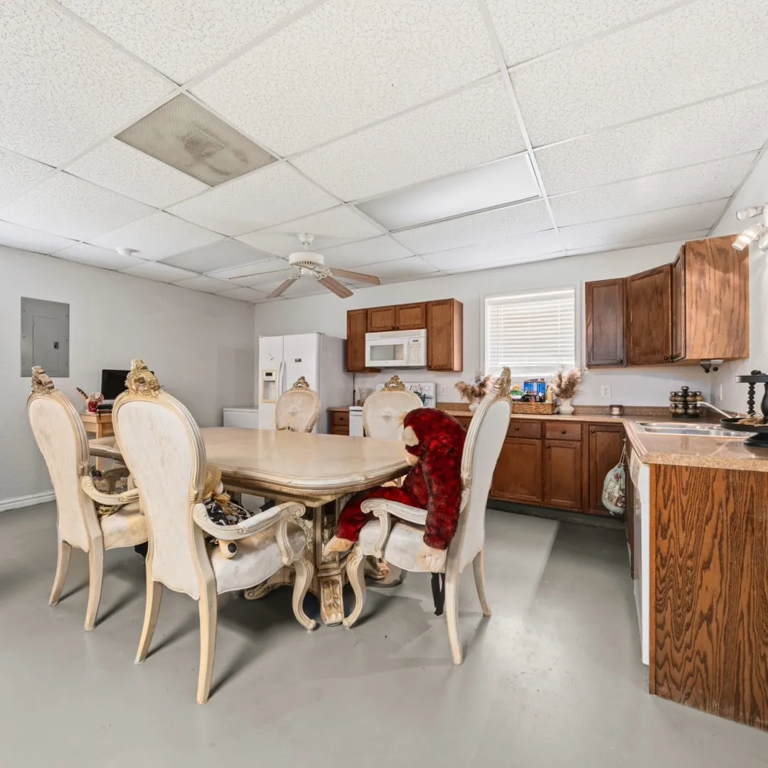 Open-concept room featuring light-toned flooring and a drop ceiling with integrated lighting