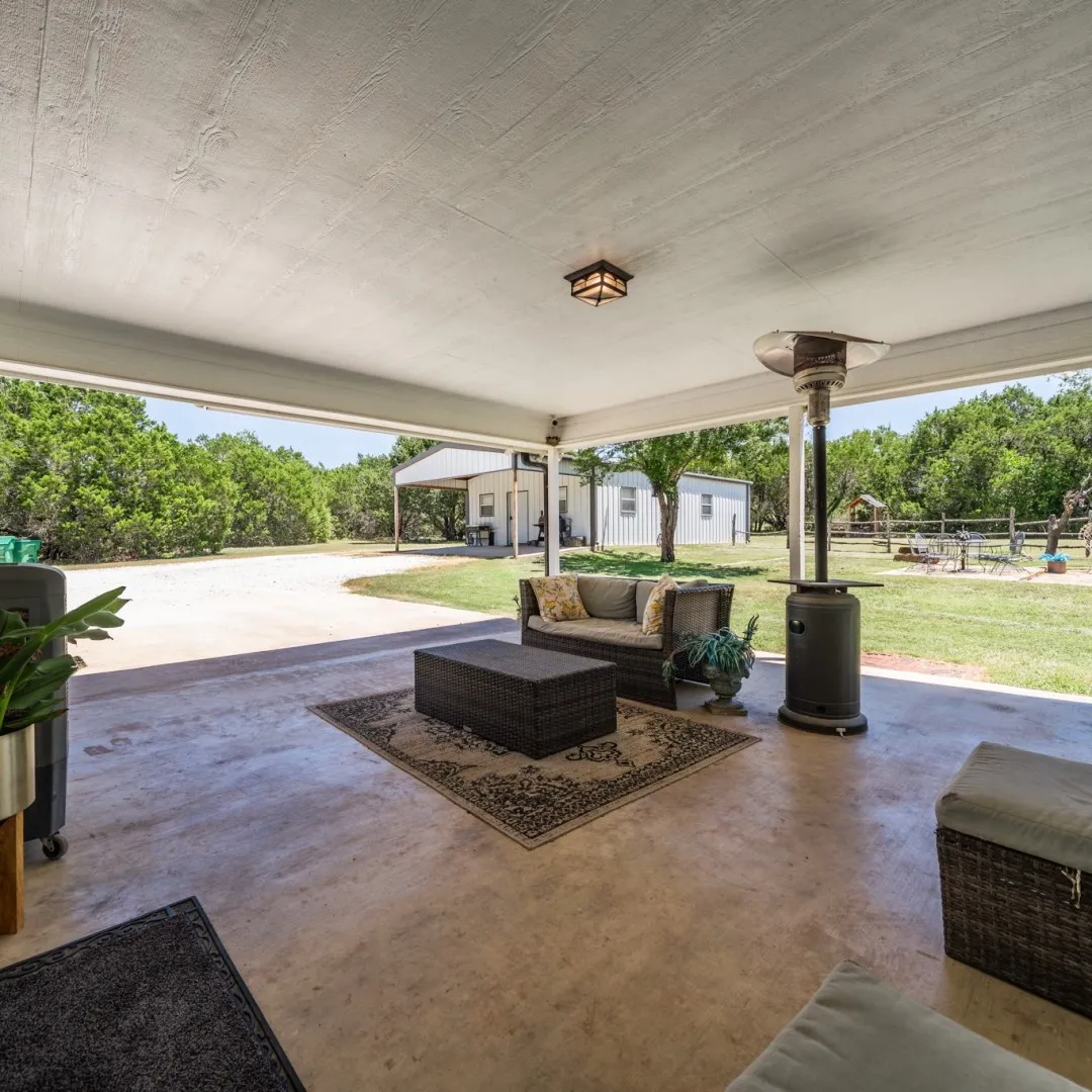 Spacious covered patio with concrete flooring and overhead lighting