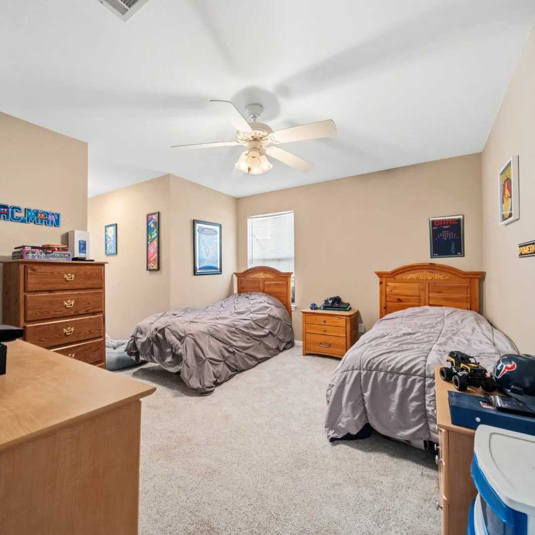 Carpeted room featuring a ceiling fan with integrated lighting, a window with blinds, and neutral-toned walls
