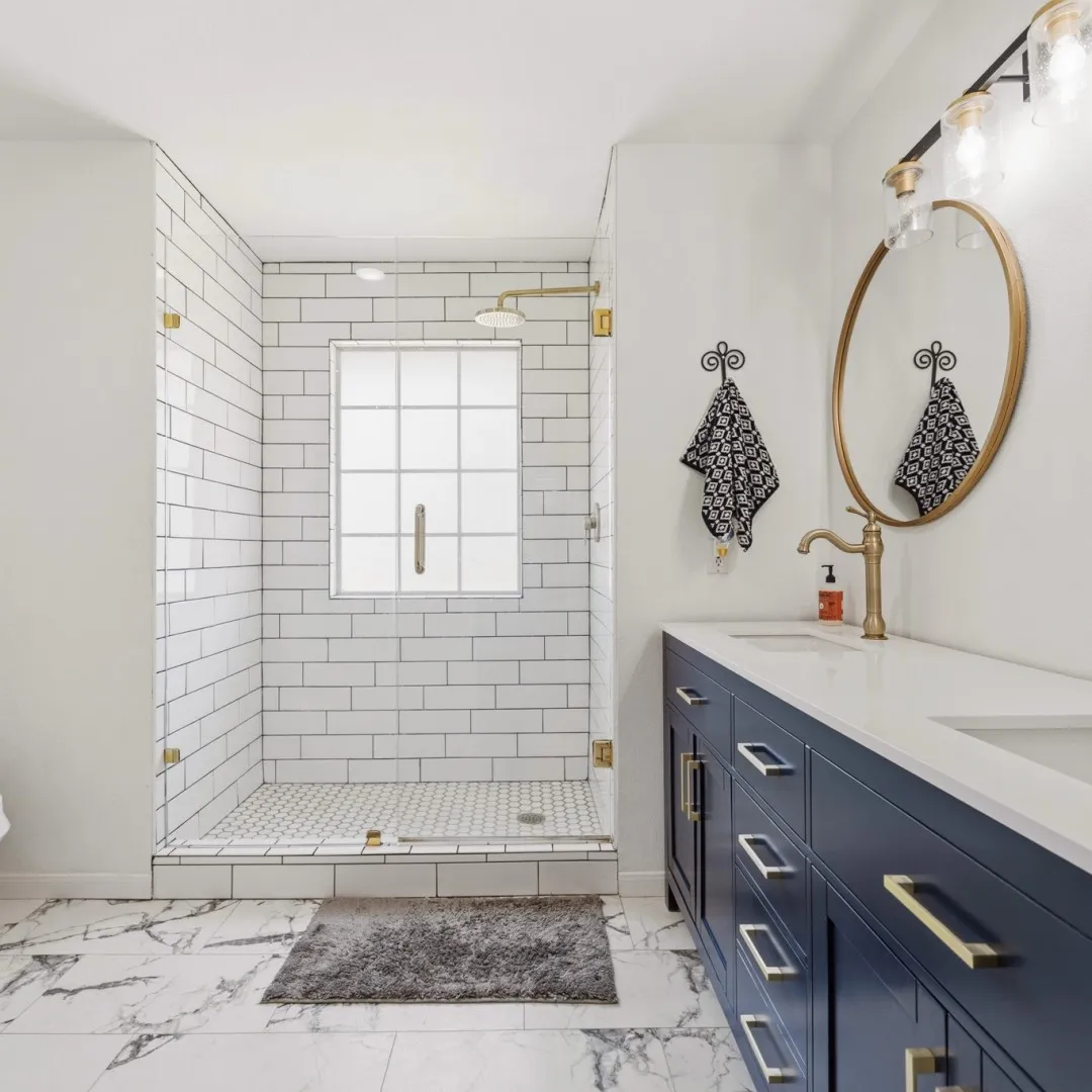 Contemporary bathroom featuring a spacious glass-enclosed shower with subway tile surround, a built-in window, and a rain showerhead with a gold-tone finish