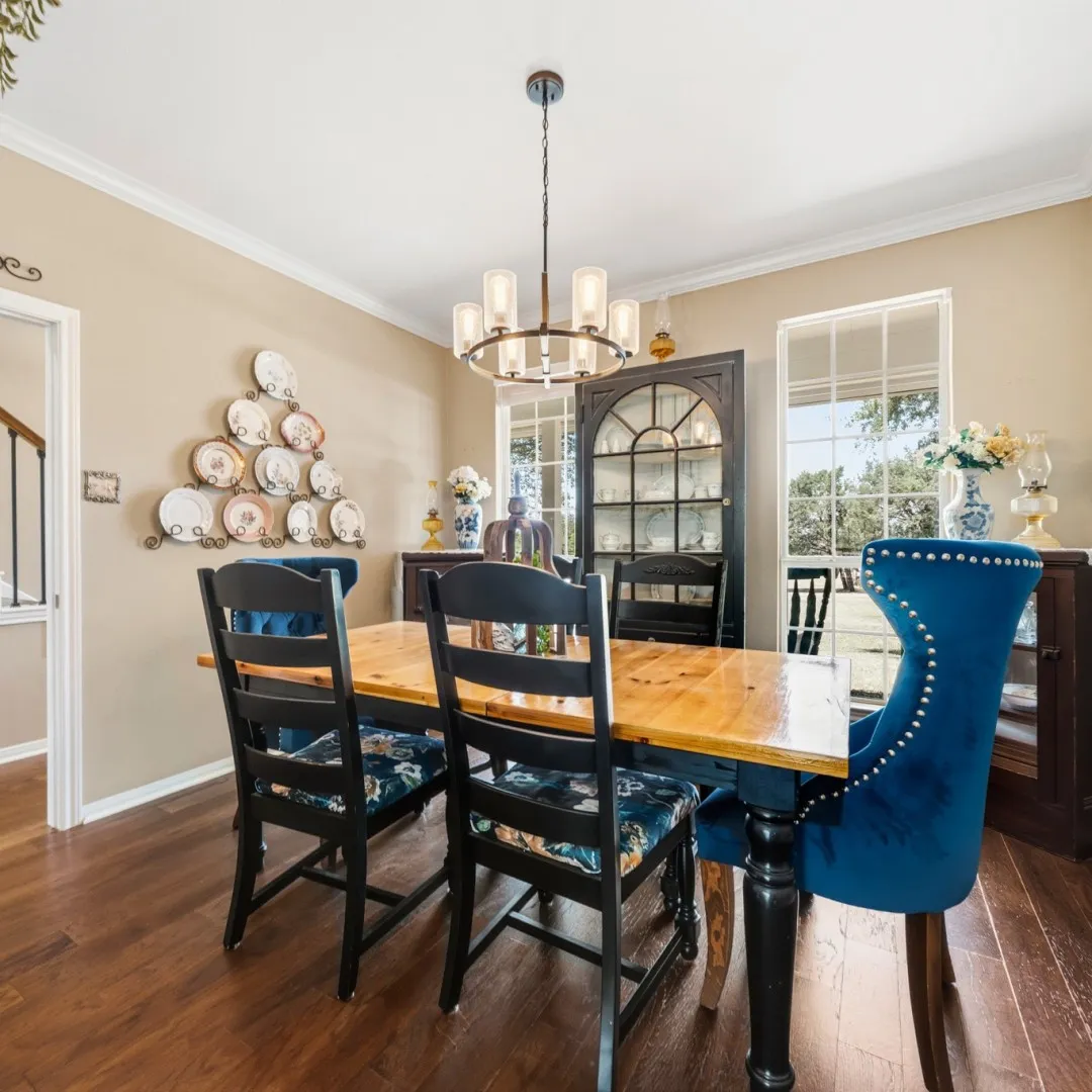 Dining area featuring wood-finish flooring, a modern chandelier with frosted glass shades, and crown molding