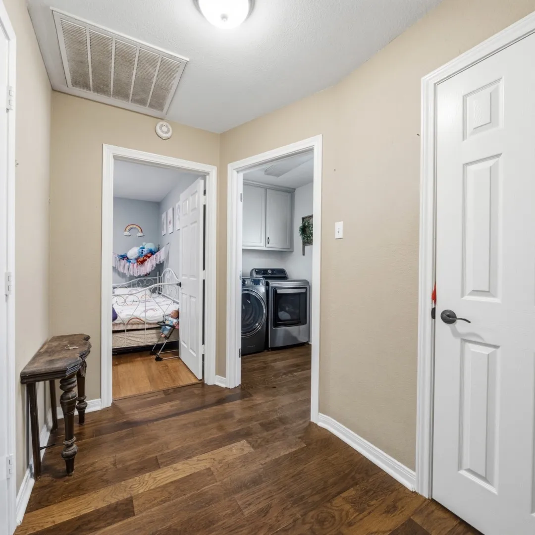 Hallway with rich wood-finish flooring