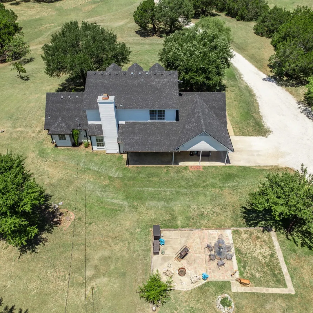 Aerial perspective showcasing a single-family residence with dark shingle roofing